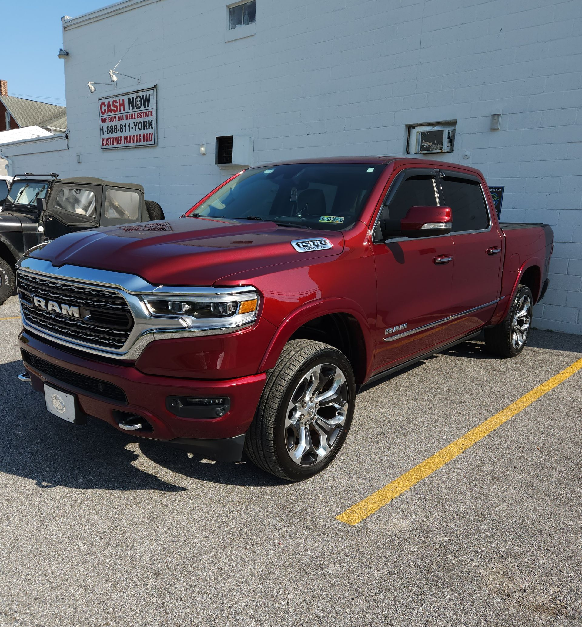 Red Ram pickup truck parked next to a building with the sun shining.