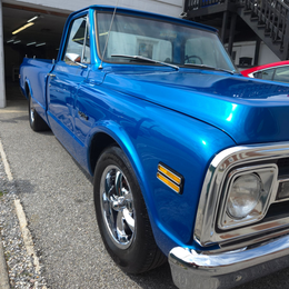 Blue vintage Chevrolet pickup truck, parked in front of a building.