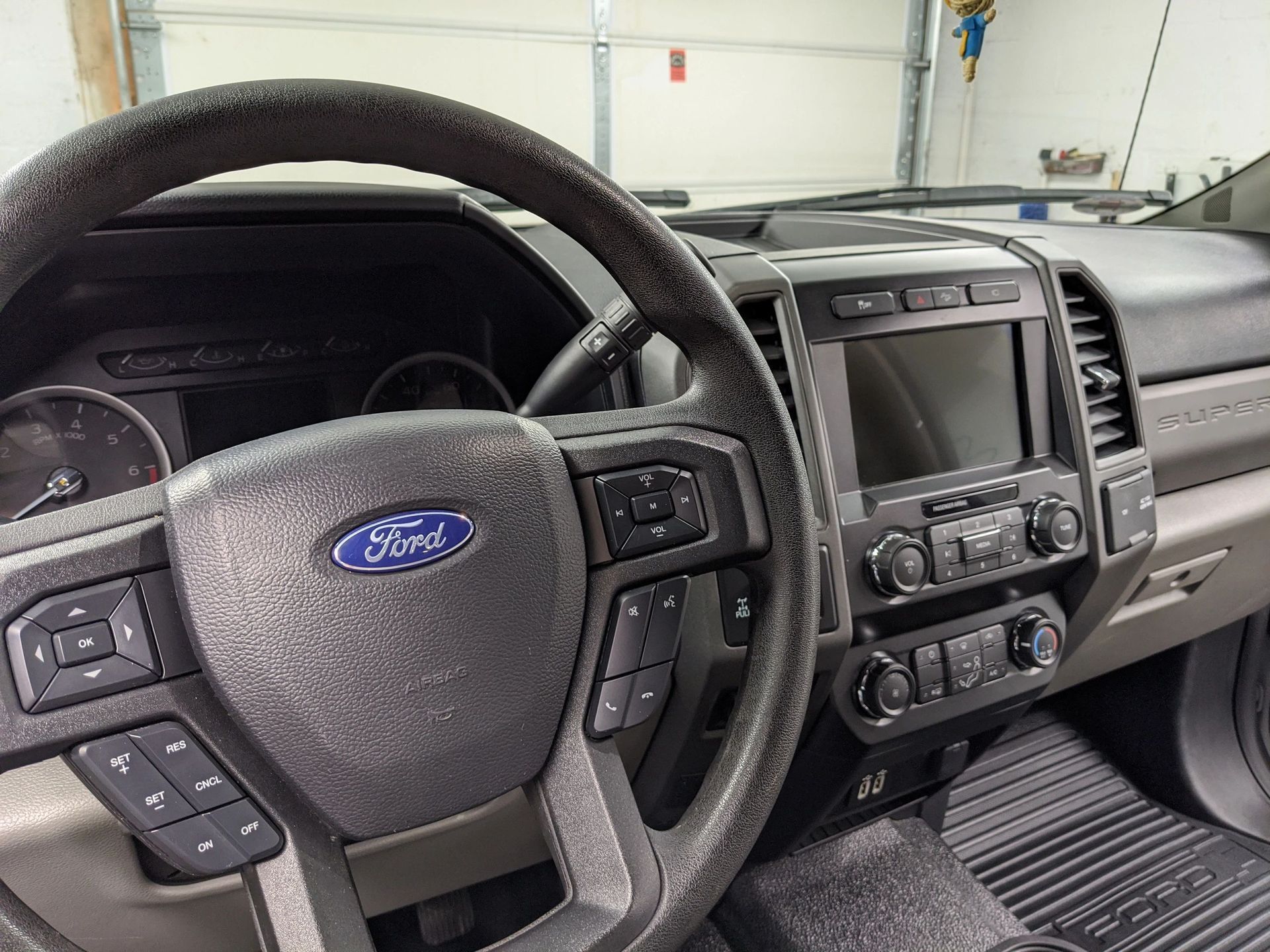 Interior of a Ford truck cab, showing the steering wheel, dashboard, and infotainment system.