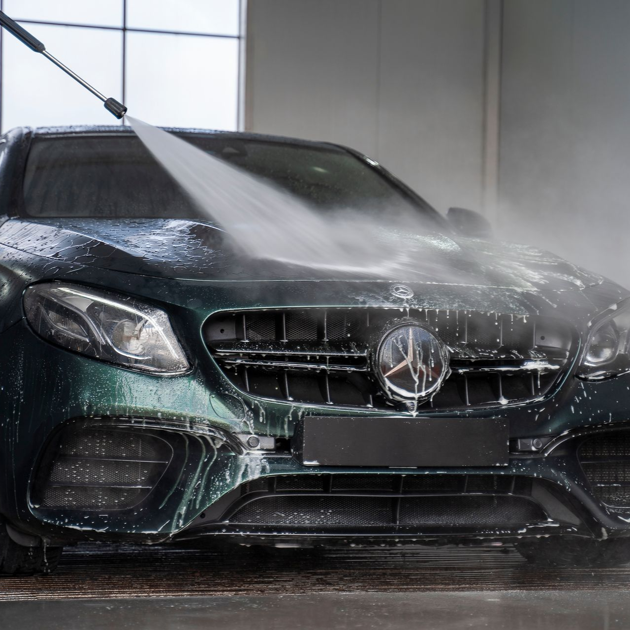 Green Mercedes being power washed.
