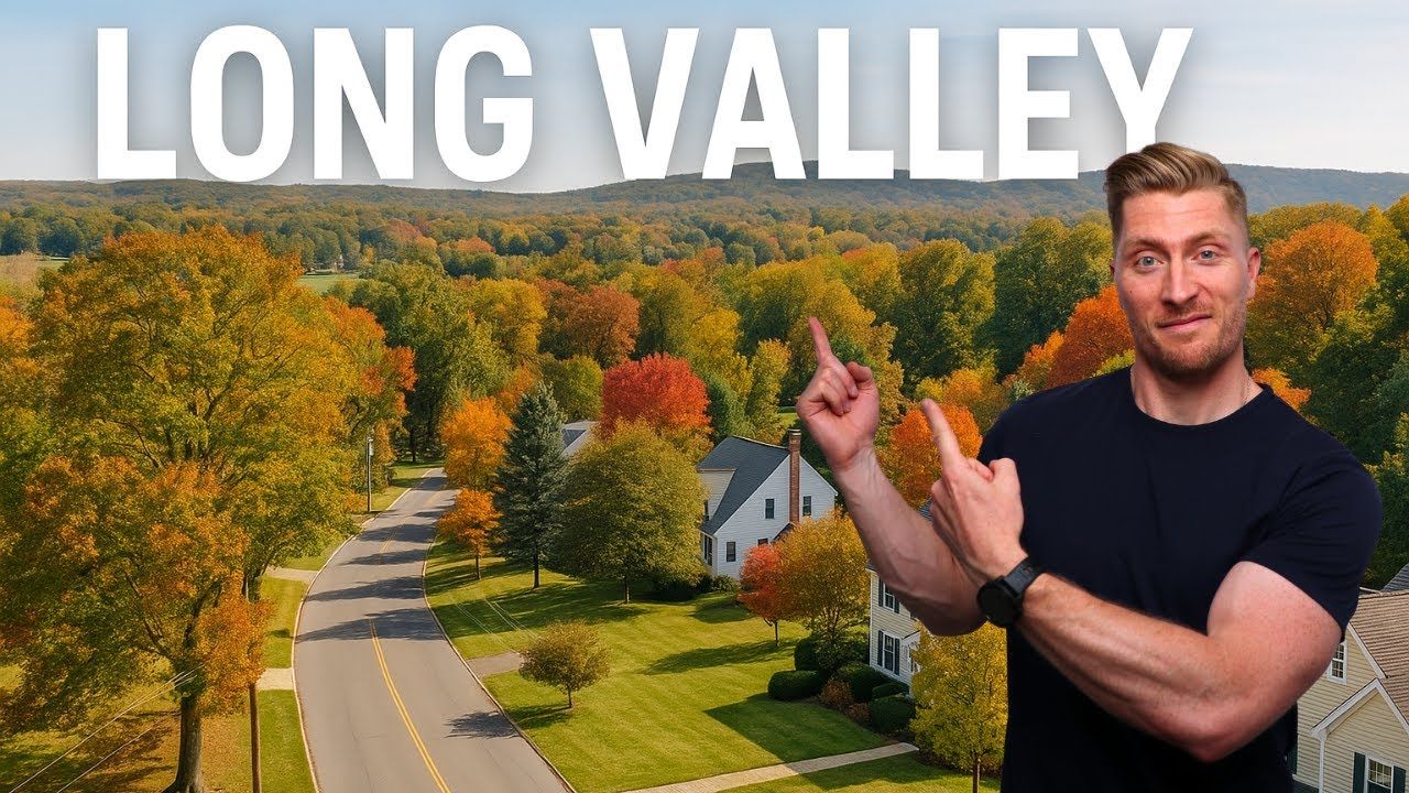 Man points at Long Valley landscape, with autumn trees and houses.