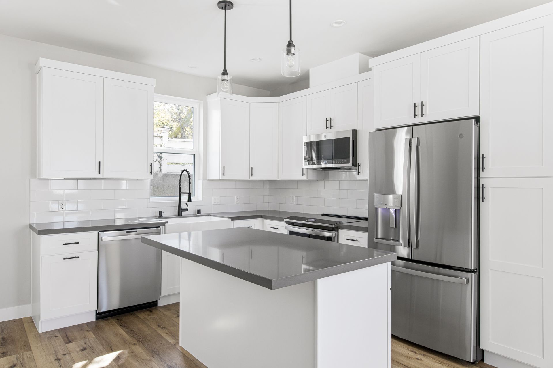 The full kitchen inside an accessory dwelling unit (ADU) backyard home, featuring plenty of space, an island, and modern all-electric appliances.