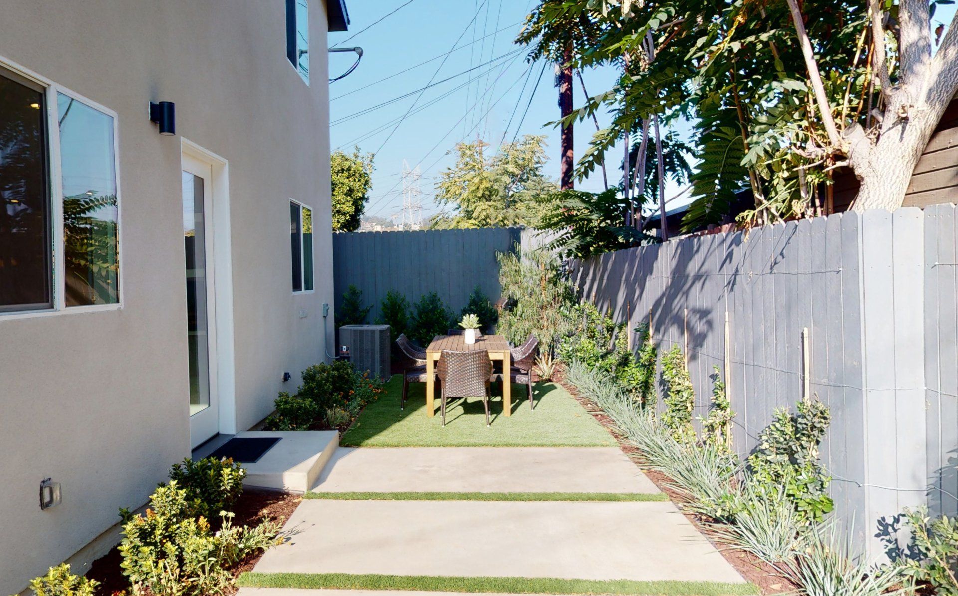 Reclaimed side yard converted into quaint outdoor patio for accessory dwelling unit (ADU) backyard home.