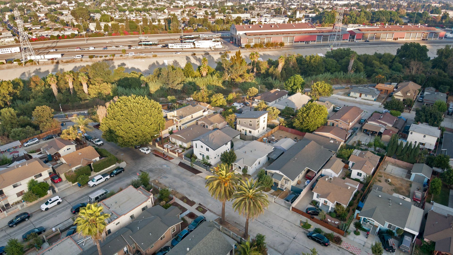 An aerial view of a street in a neighborhood in Los Angeles, CA with multiple houses that have had accessory dwelling units (ADUs) built on their properties. 