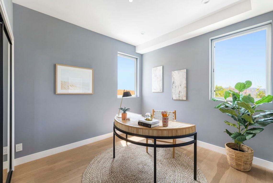 A sunny secondary bedroom in an accessory dwelling unit (ADU) backyard home being used as an office.