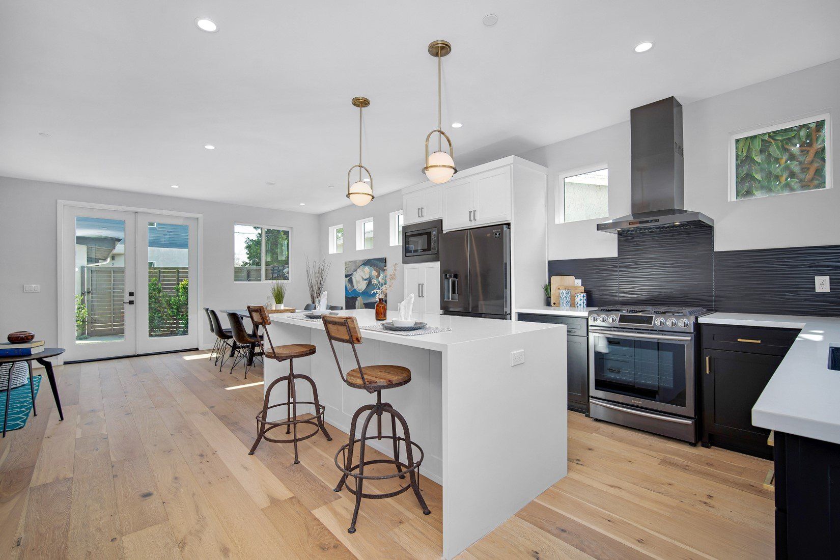 The full kitchen inside an accessory dwelling unit (ADU) backyard home, featuring plenty of space, an island, and modern all-electric appliances.
