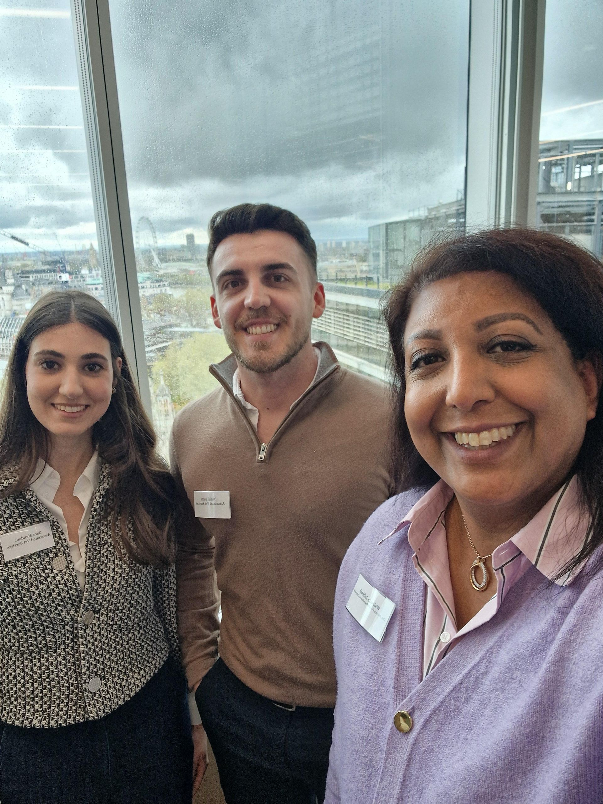 Two people hold a donation check for £1,100 for Birmingham Dogs Home in front of a large, bright yellow sculpture.