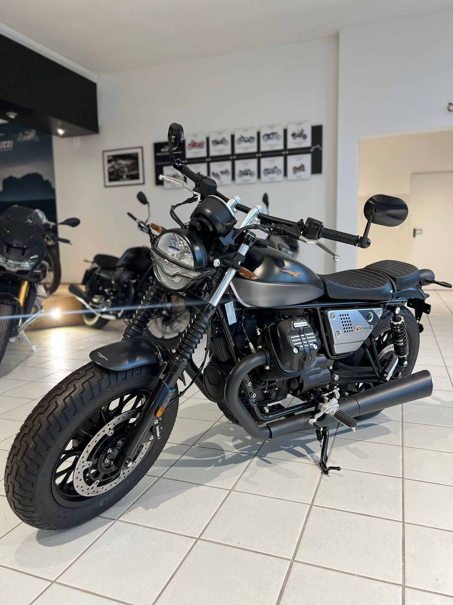 Una moto è parcheggiata in uno showroom accanto a un'altra moto.