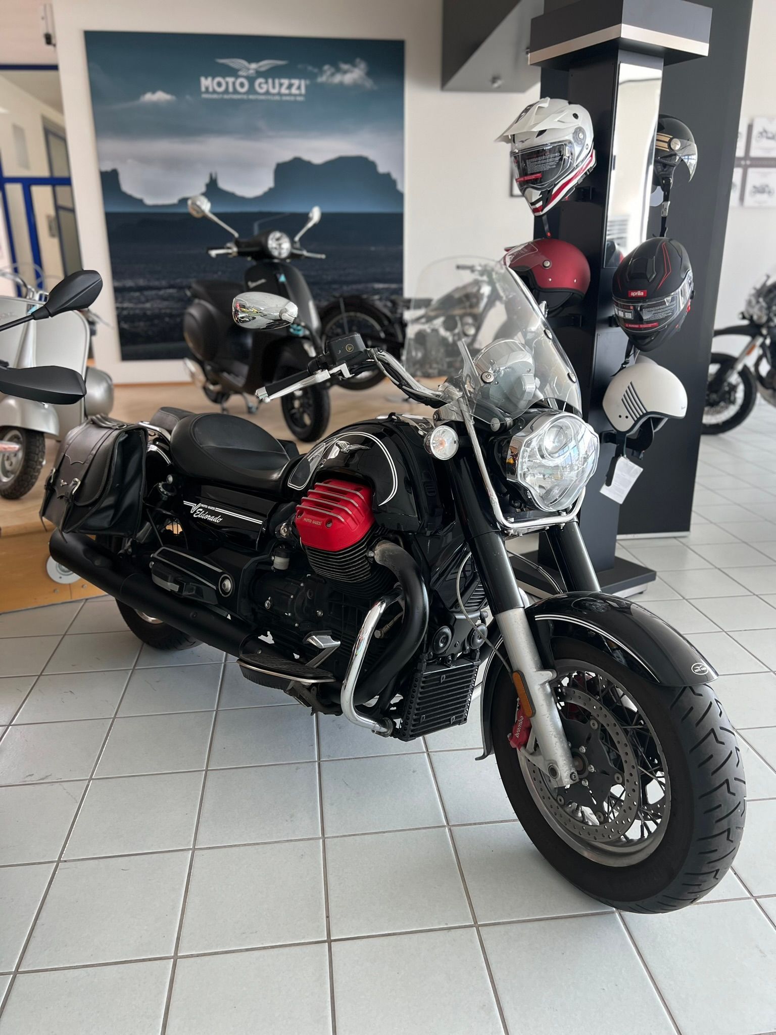 Una moto nera e rossa è parcheggiata in uno showroom.