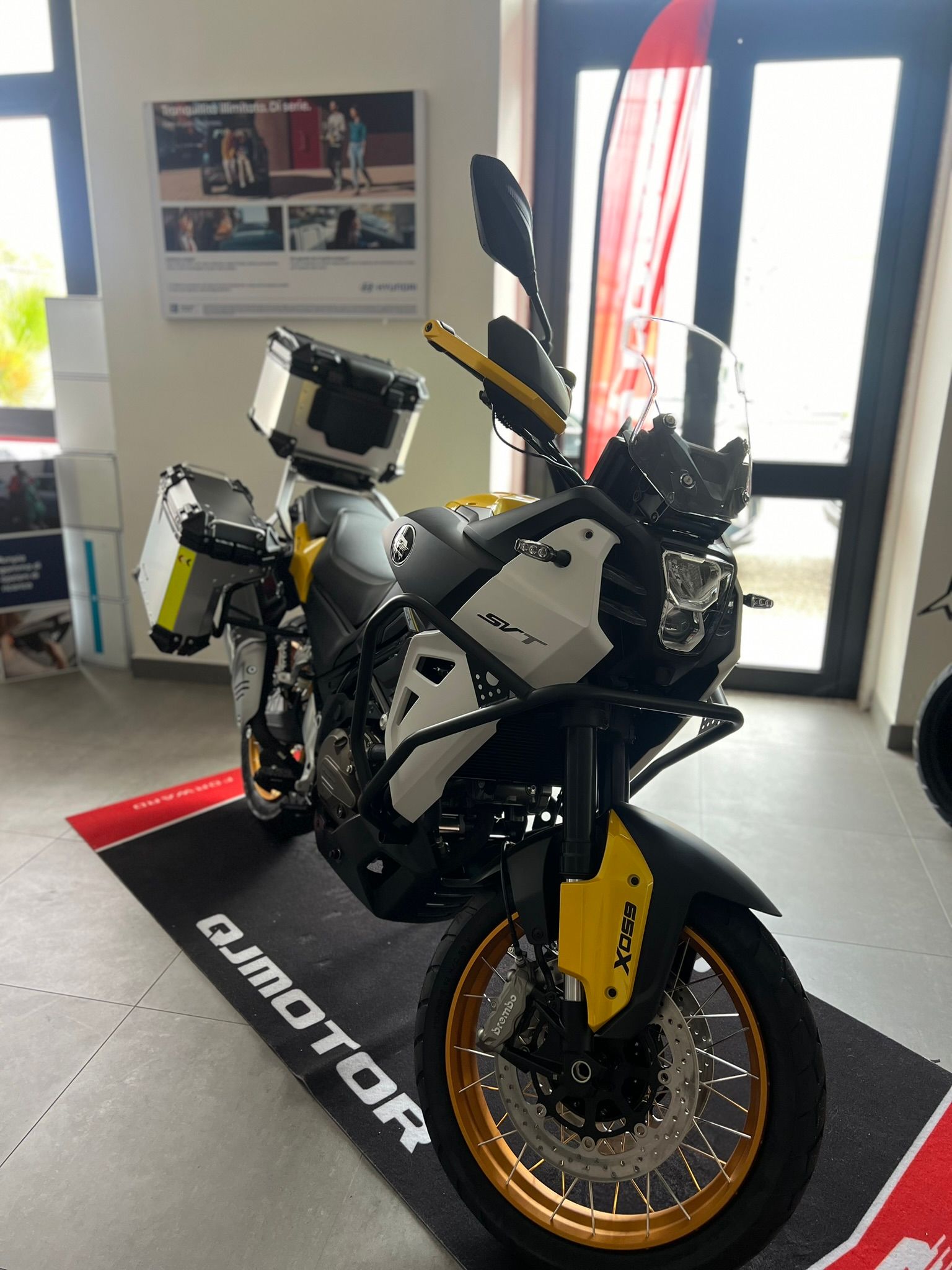 Una moto nera e gialla è parcheggiata su uno zerbino in una stanza.