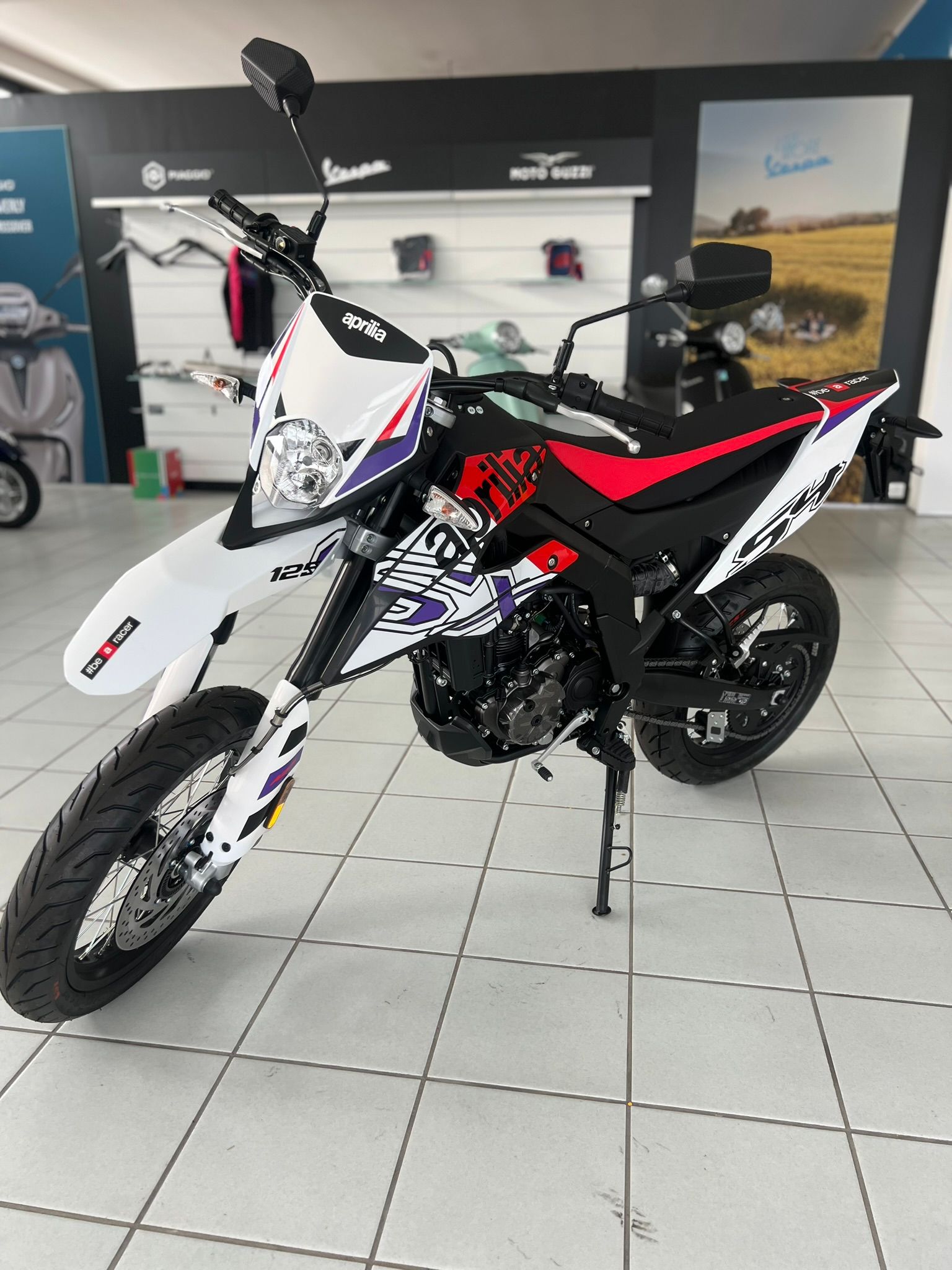 Una motocicletta è parcheggiata su un pavimento piastrellato in uno showroom.