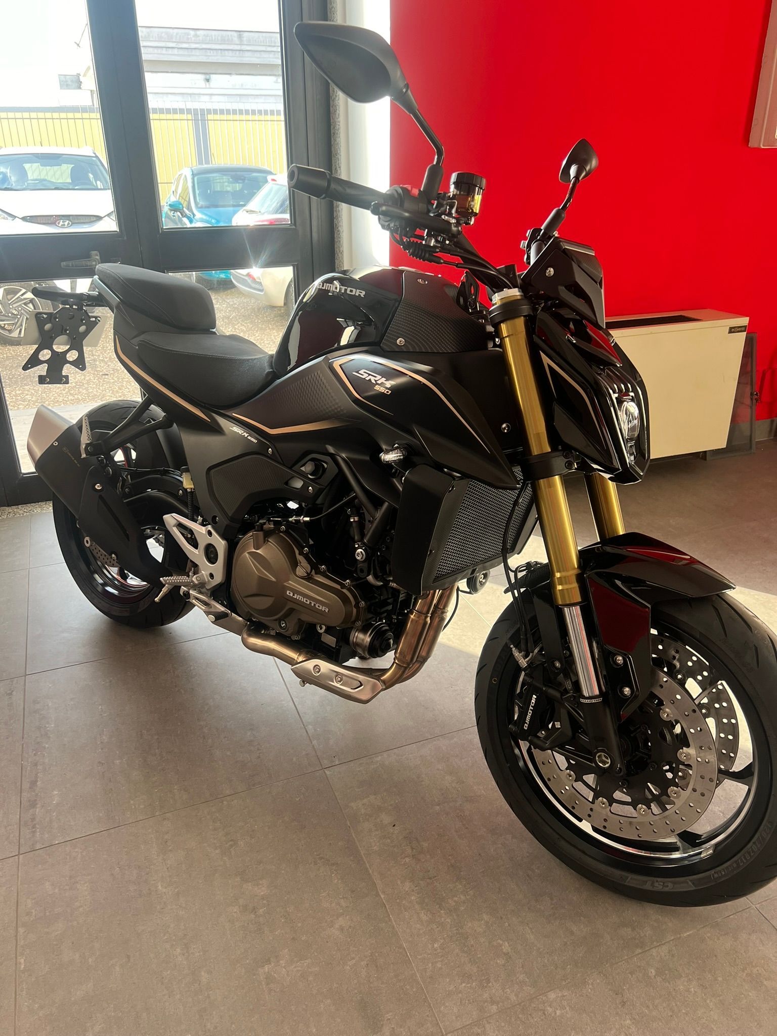 Una motocicletta nera è parcheggiata in uno showroom.