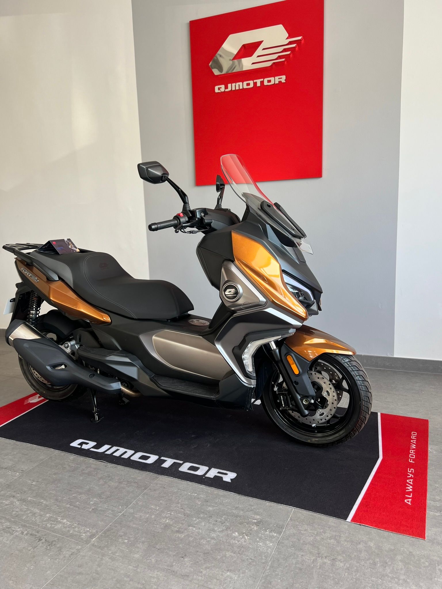 Uno scooter è parcheggiato su uno zerbino in una stanza.