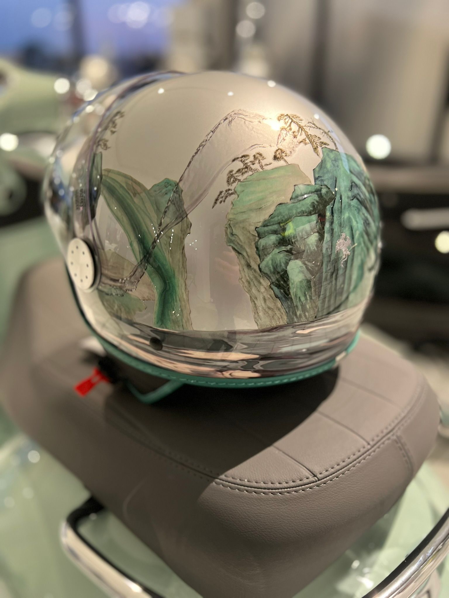 Un casco è appoggiato sul sedile di uno scooter.