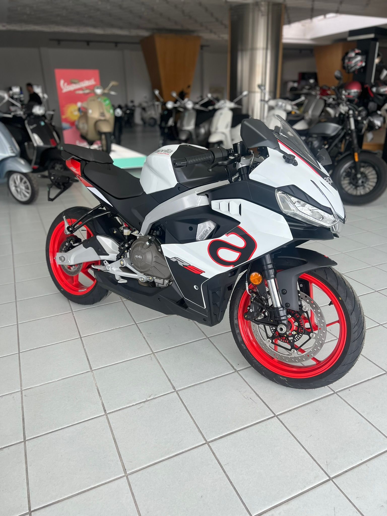Una moto bianca e nera è parcheggiata in uno showroom.