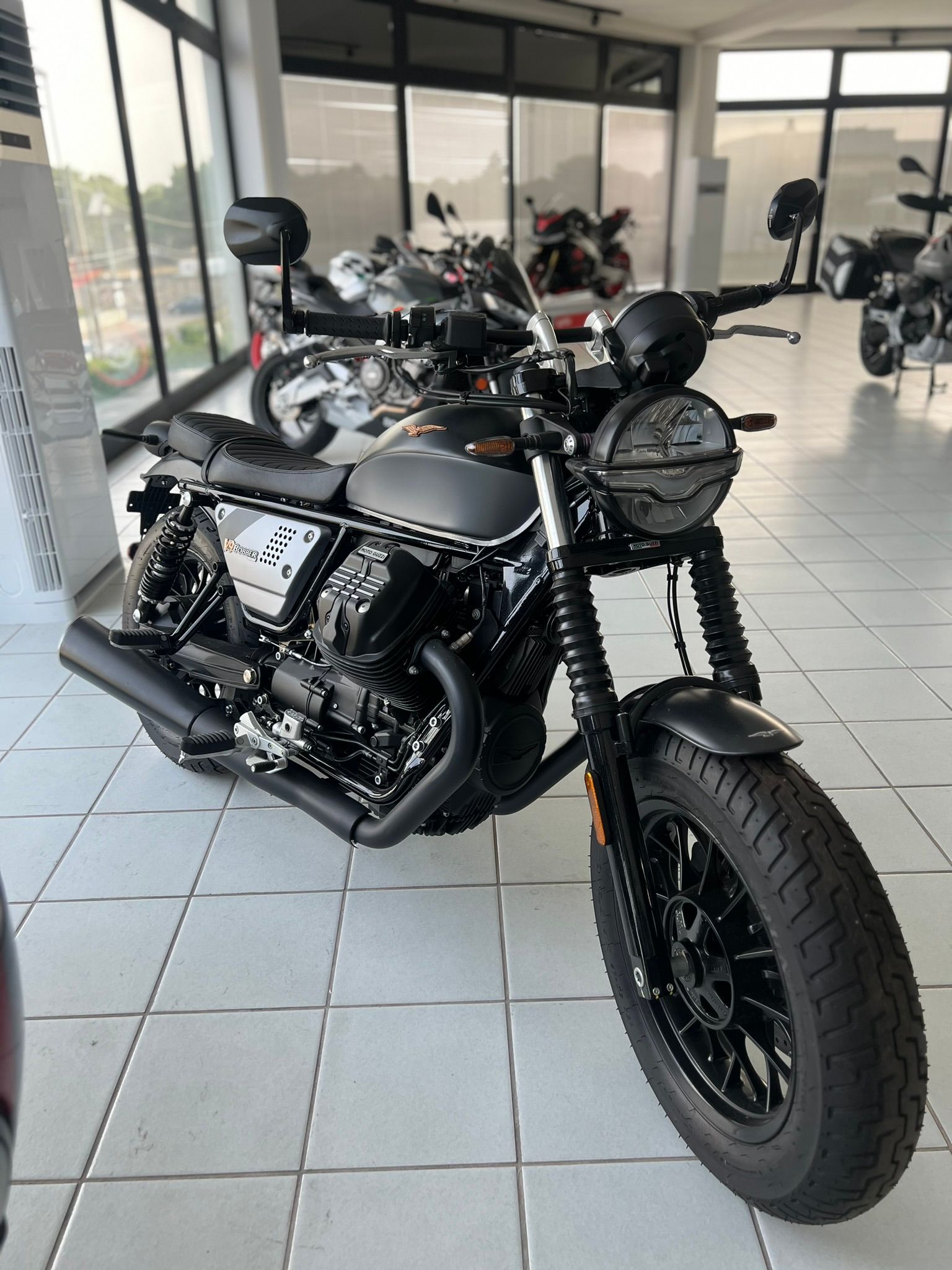 Una moto nera è parcheggiata in uno showroom.