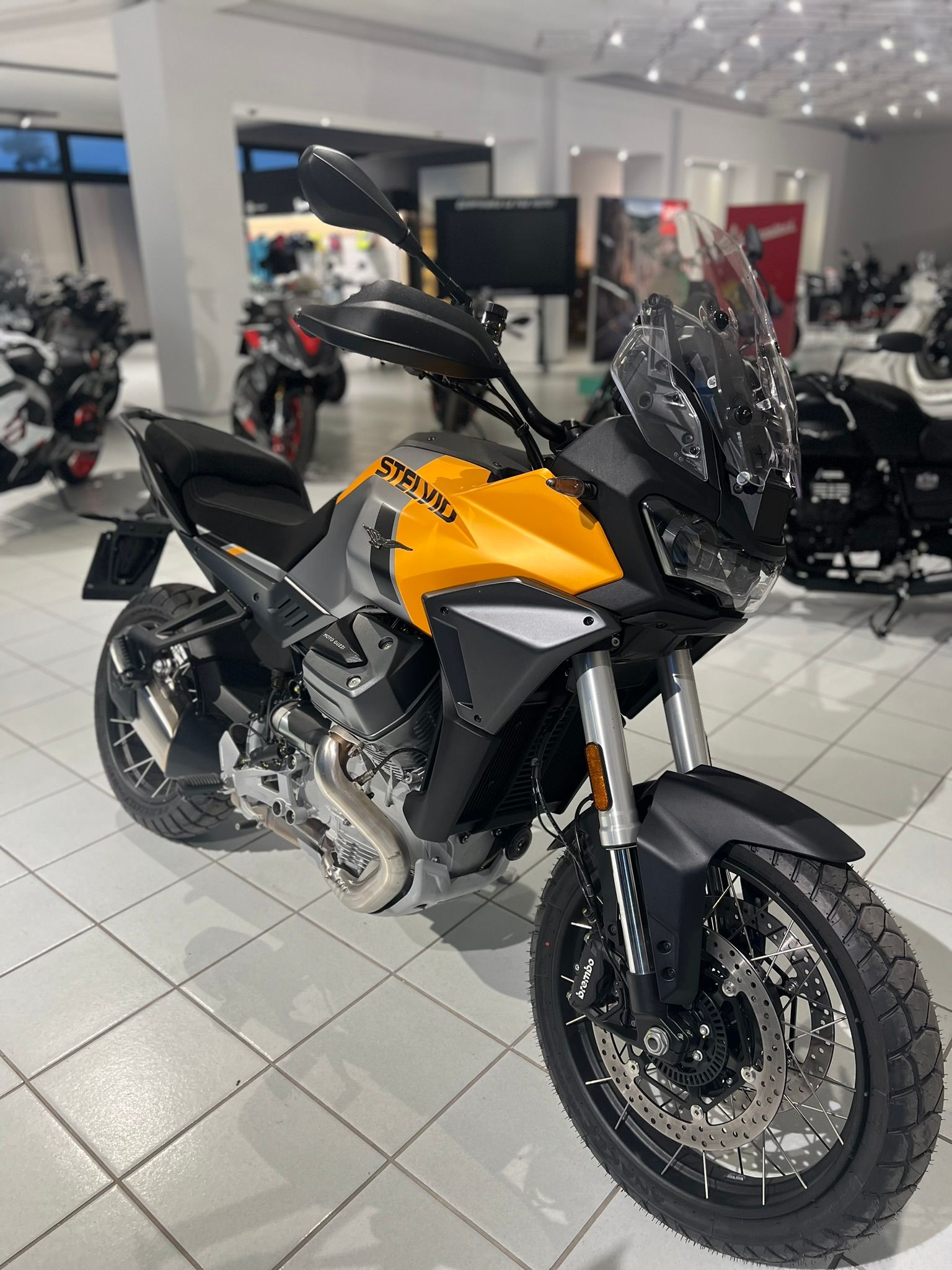 Una moto gialla e nera è parcheggiata in uno showroom.