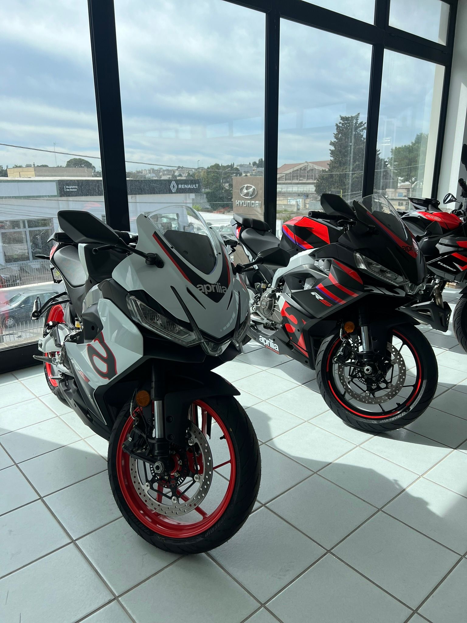 Due moto sono parcheggiate in uno showroom, una accanto all'altra.