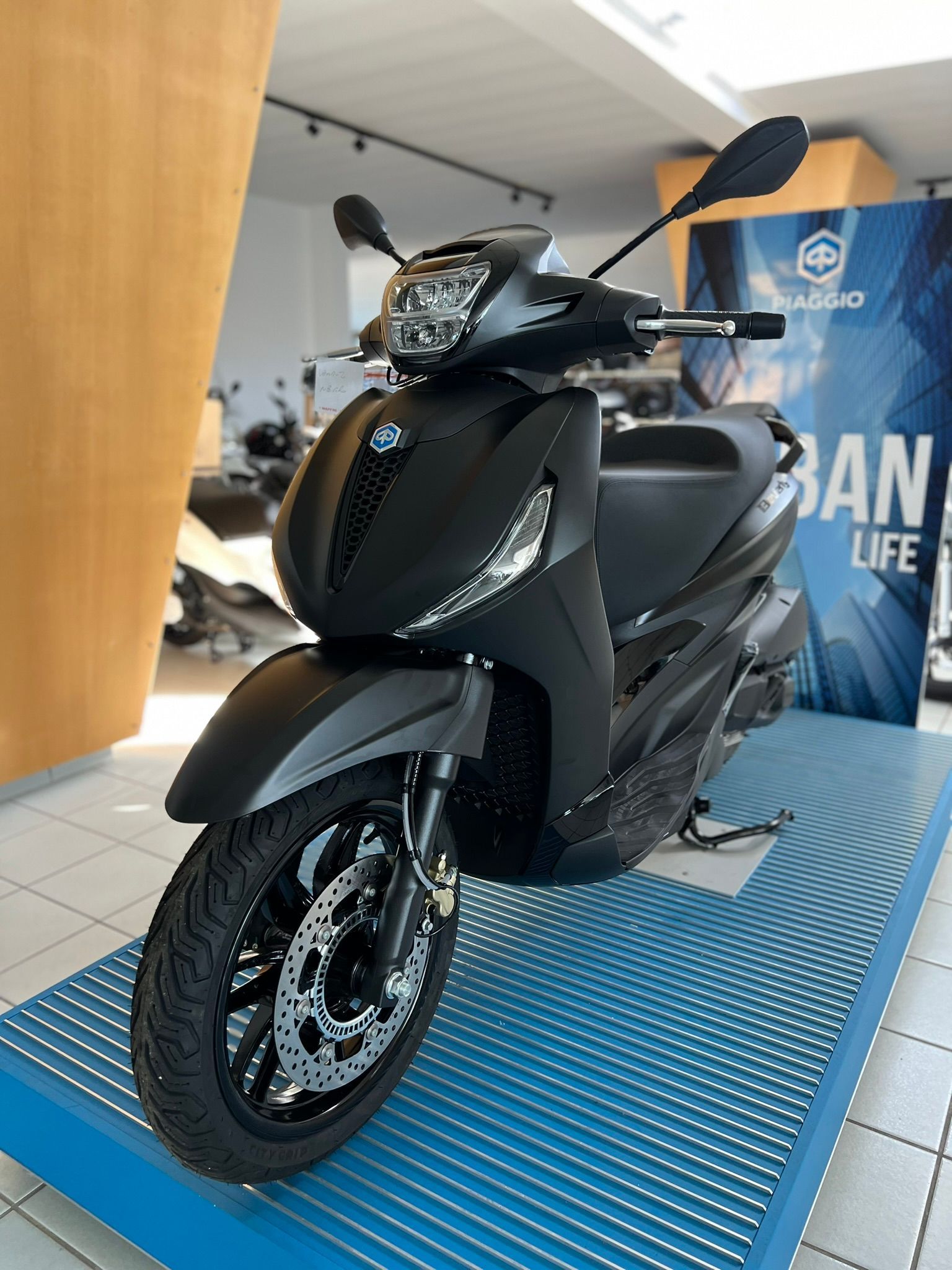 Uno scooter nero è esposto in uno showroom.