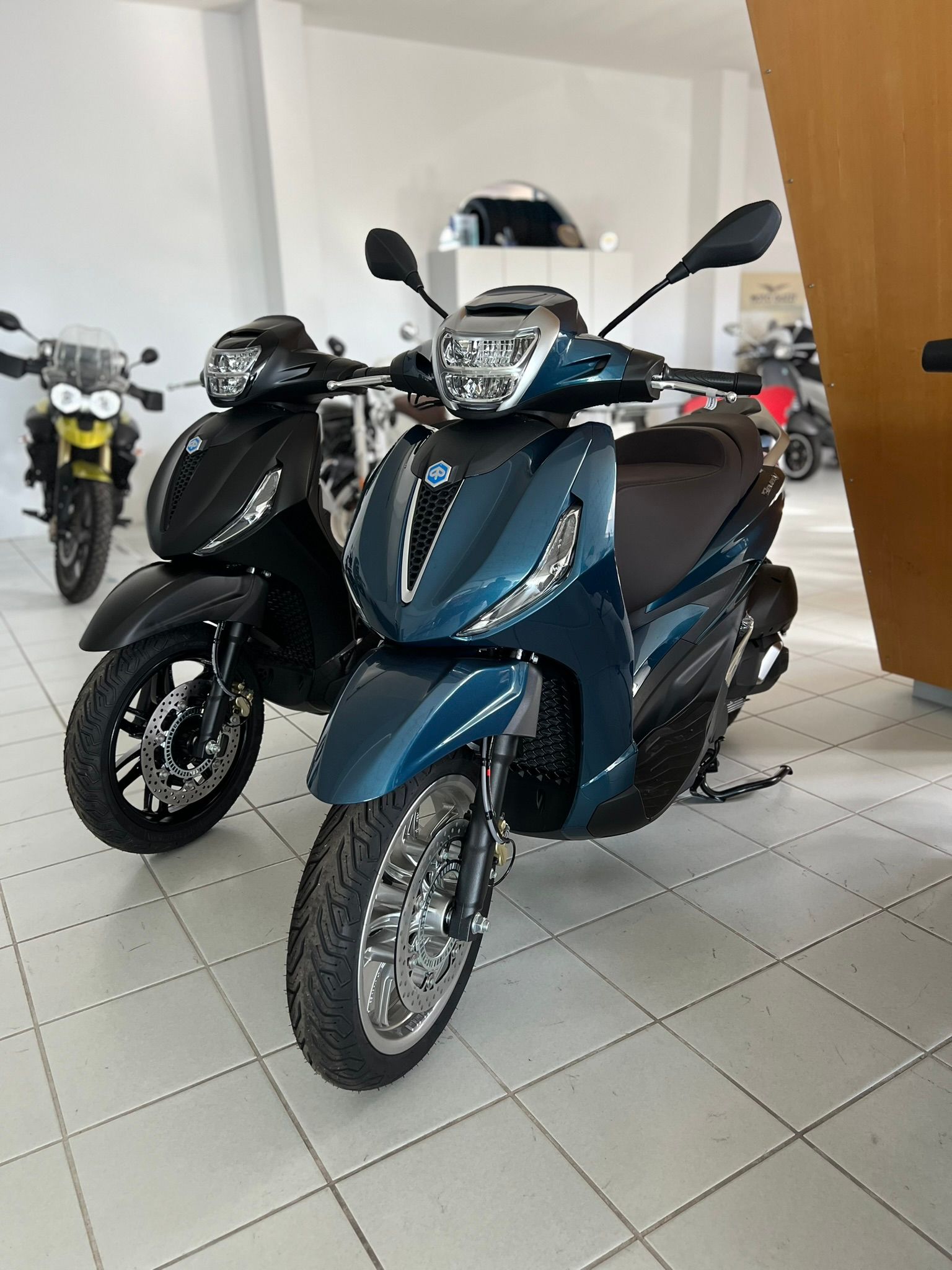 Due scooter sono parcheggiati uno accanto all'altro in uno showroom.