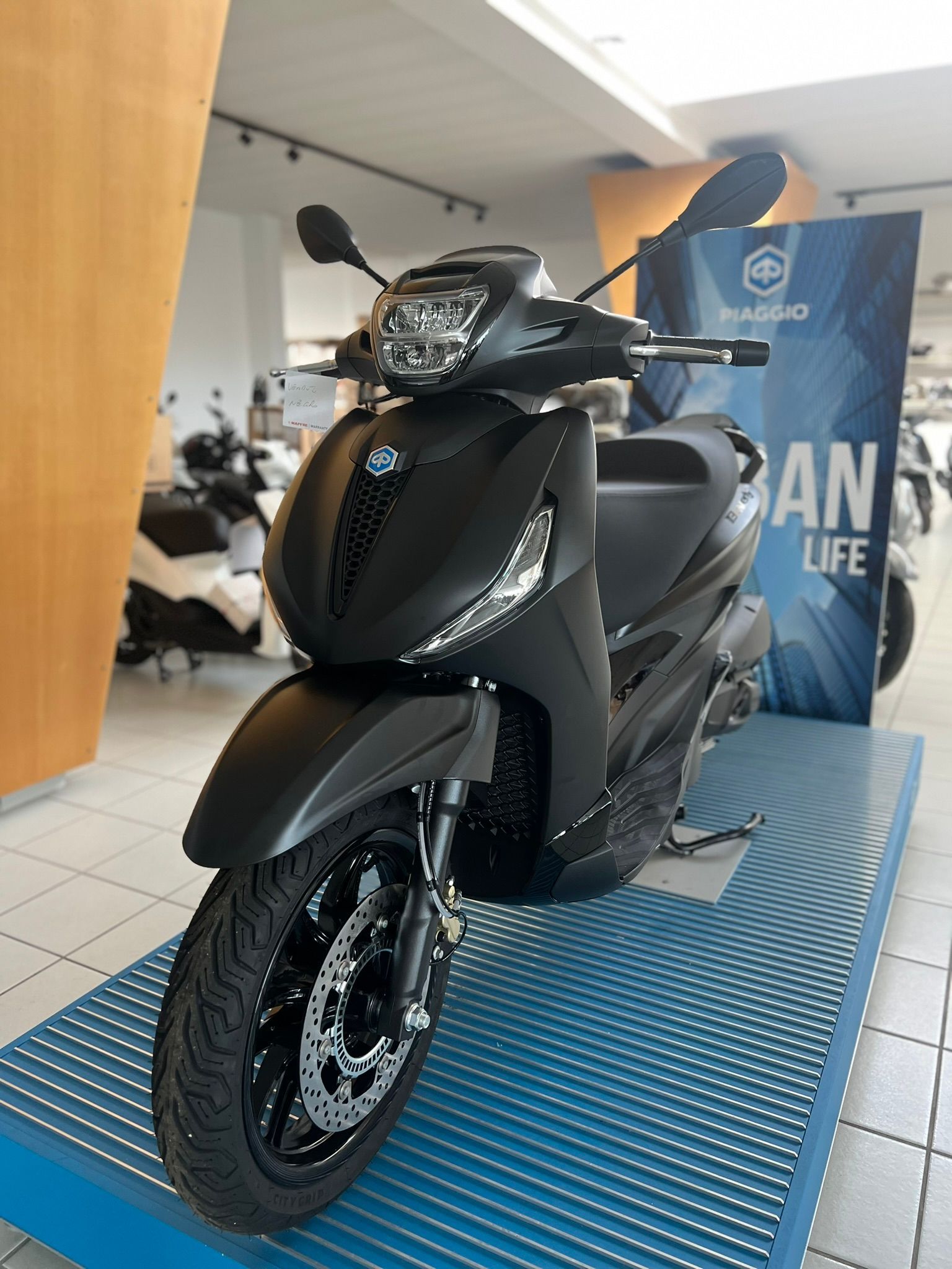 Uno scooter nero è esposto in uno showroom.
