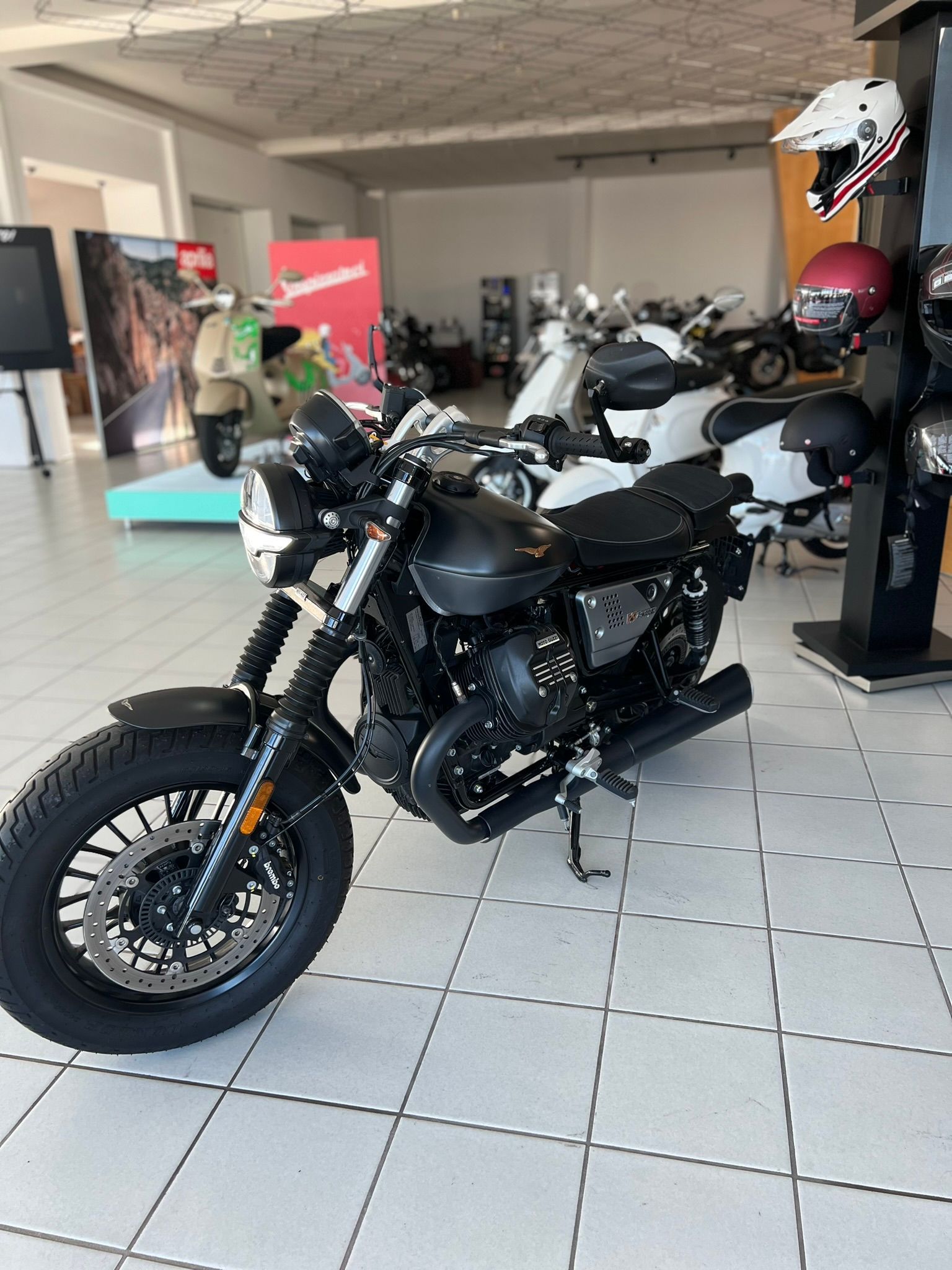 Una moto bianca e nera è parcheggiata in uno showroom.