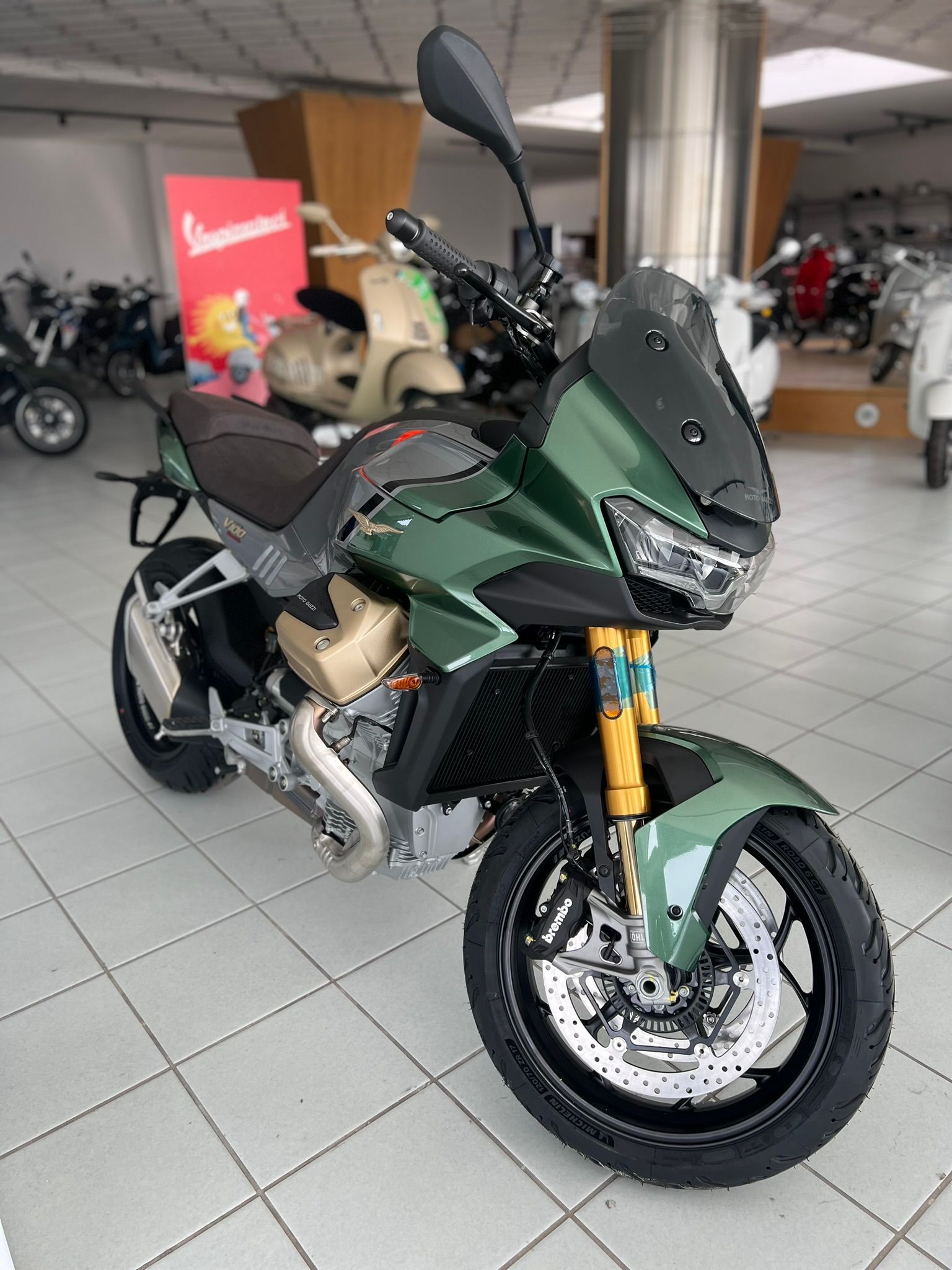Una moto verde è parcheggiata in uno showroom.