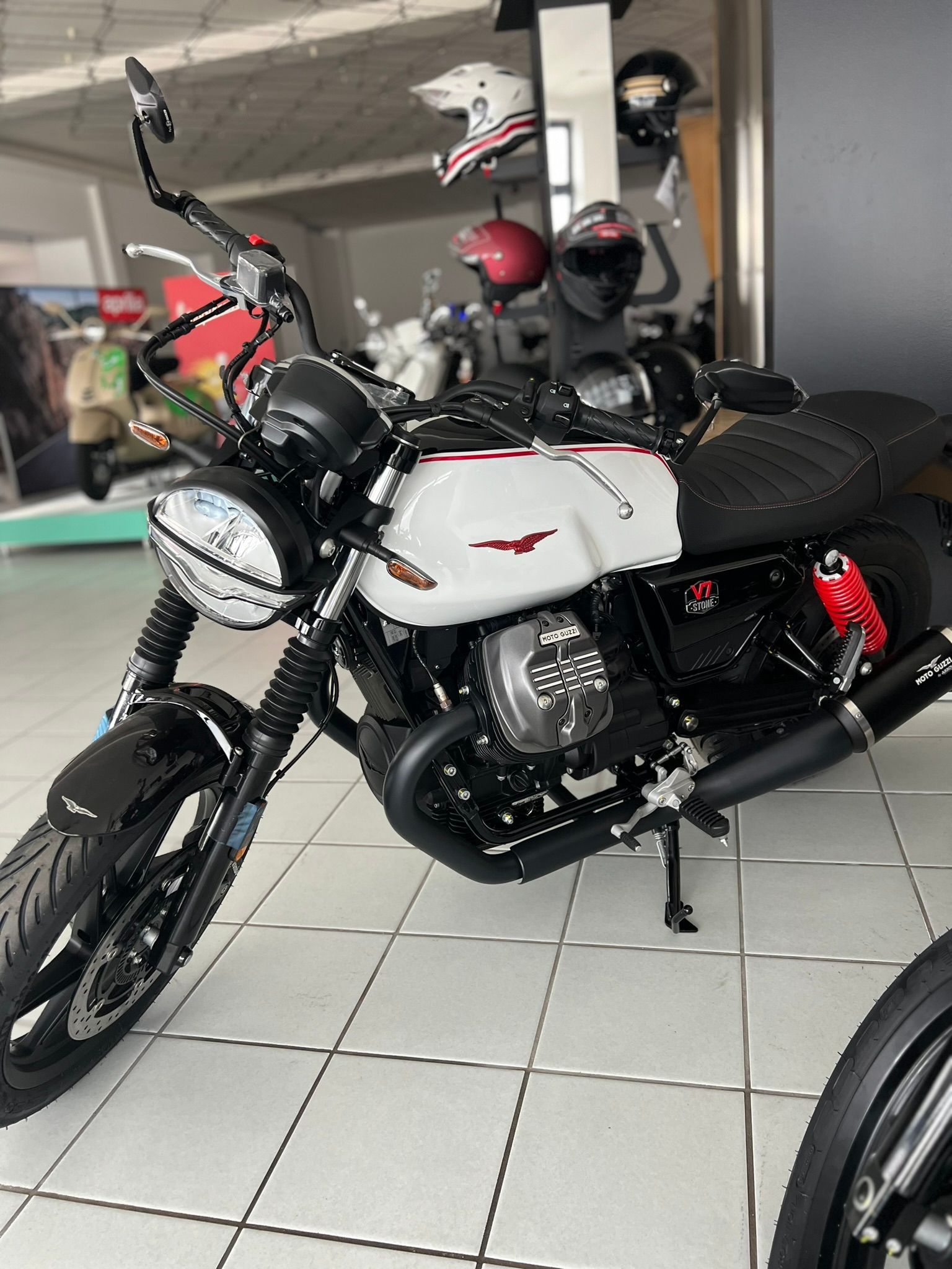 Una moto bianca e nera è parcheggiata in uno showroom.