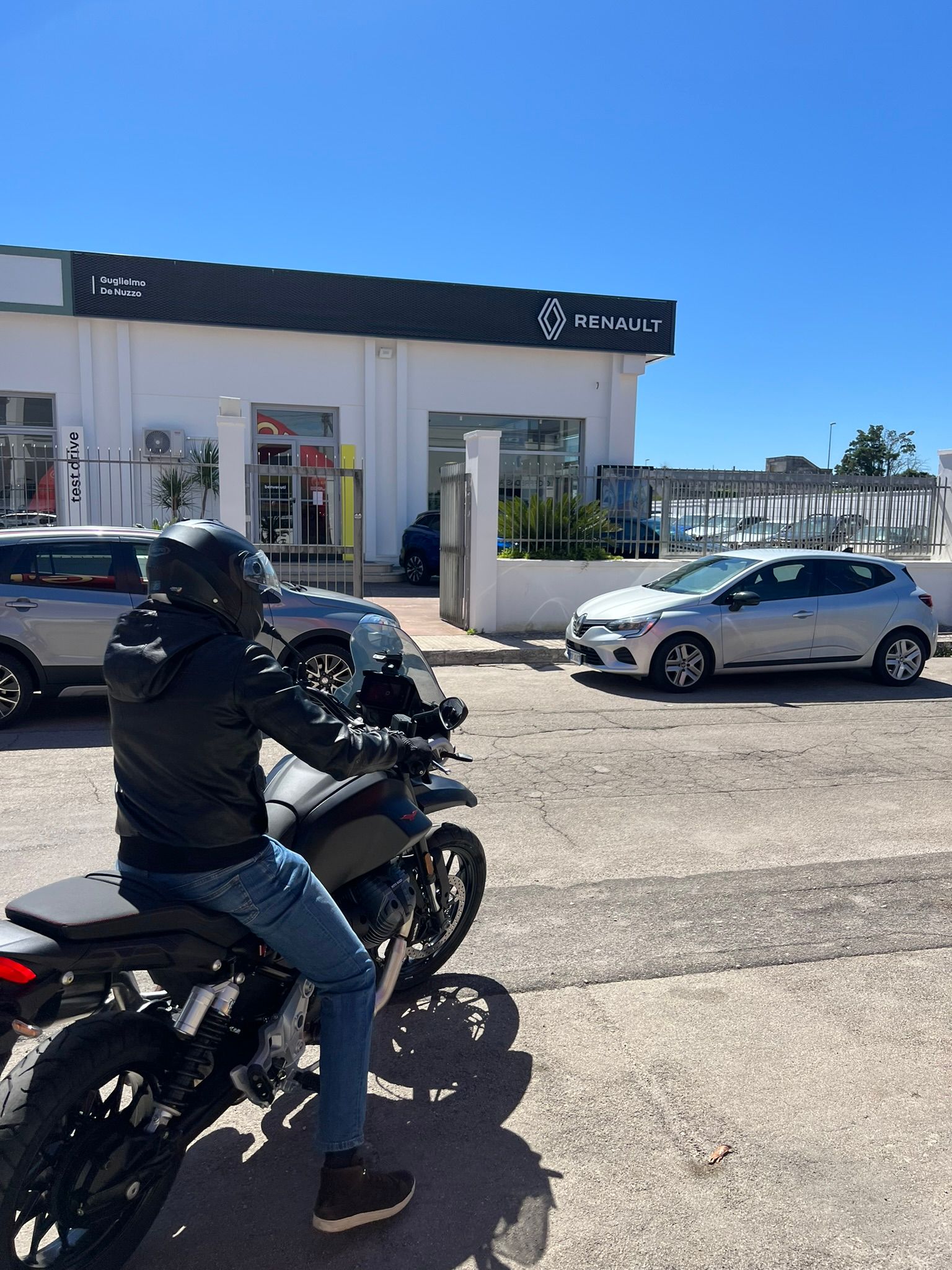 Un uomo sta guidando una moto in un parcheggio.