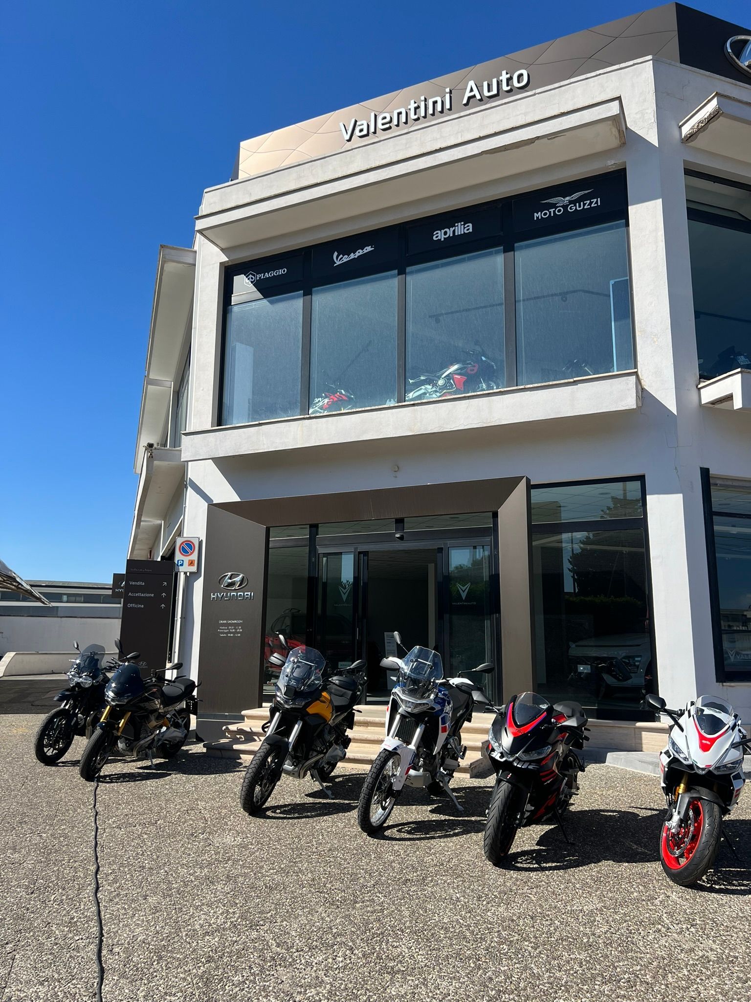 Una fila di moto è parcheggiata davanti a un edificio.
