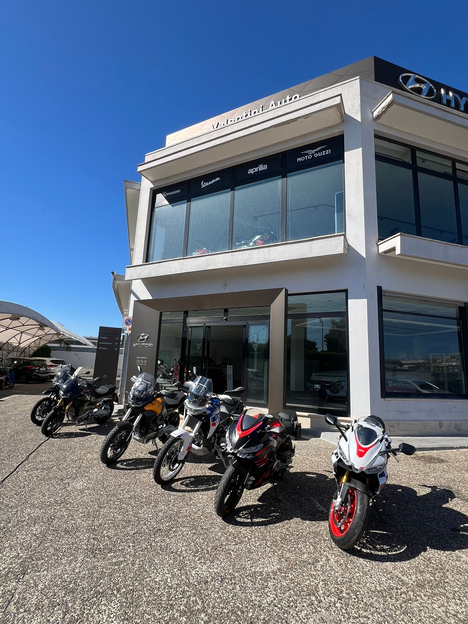 Una fila di moto è parcheggiata davanti a un edificio.