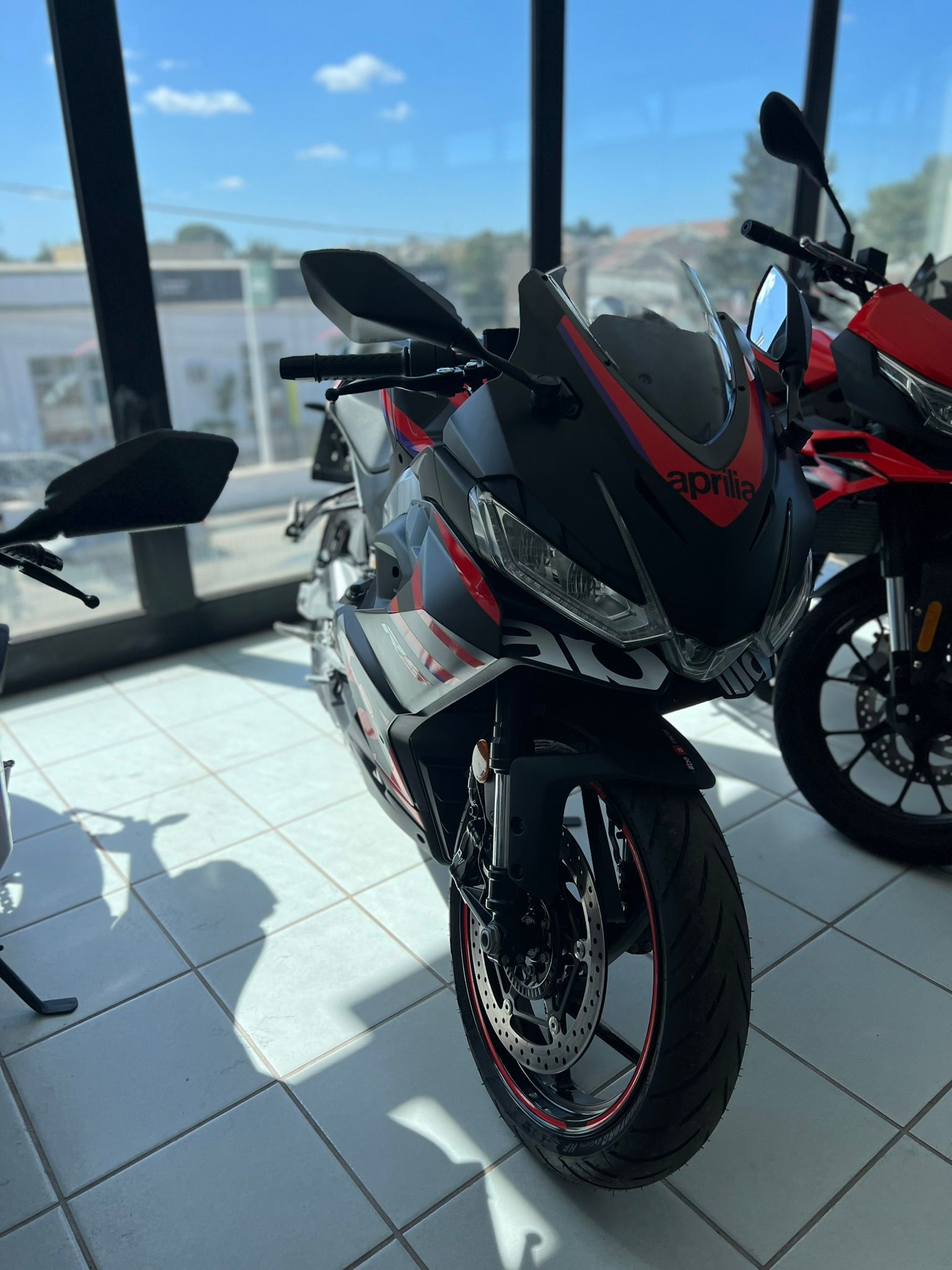 Una moto nera e rossa è parcheggiata in uno showroom.
