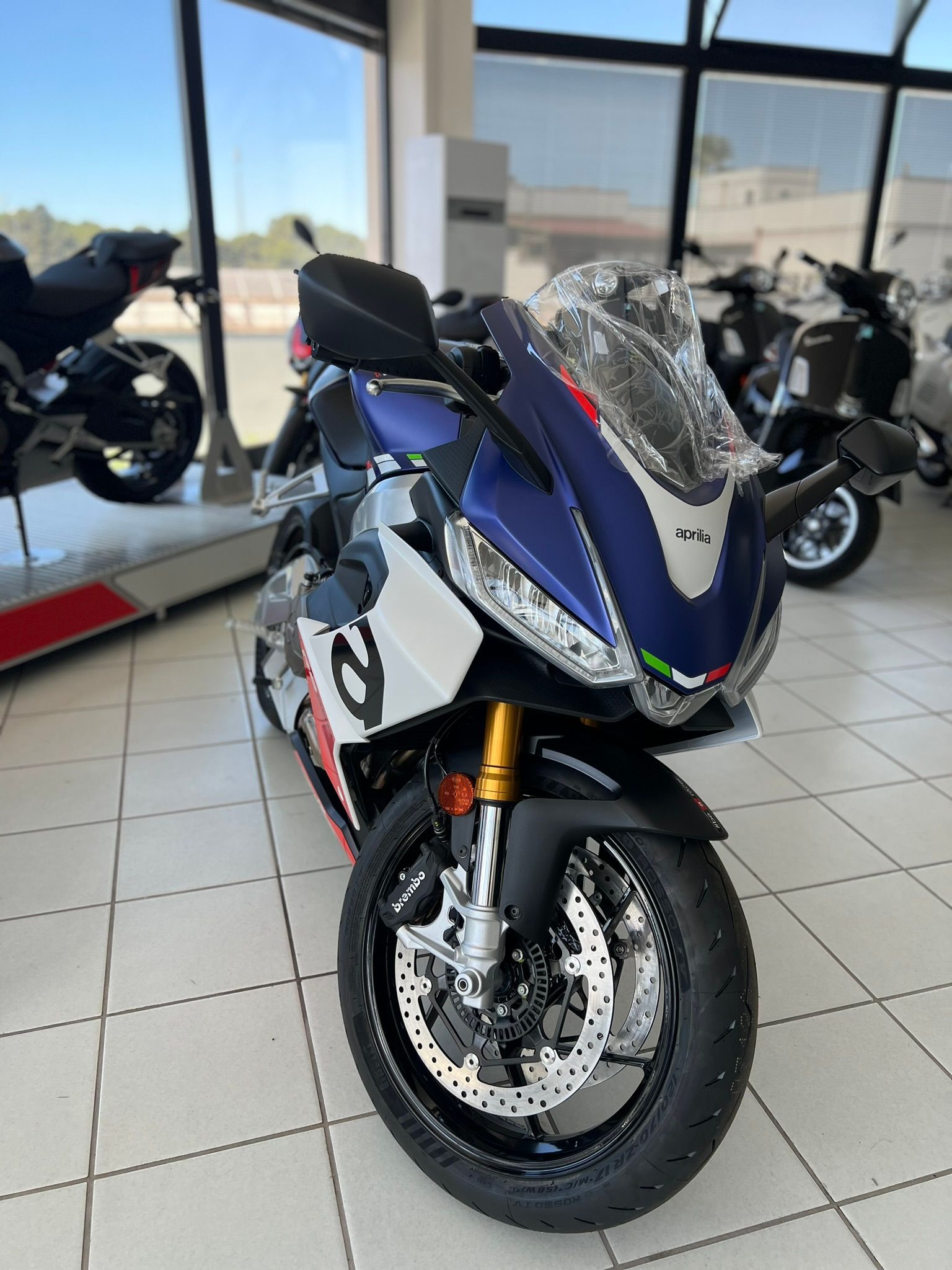 Una moto blu e bianca è parcheggiata in uno showroom.
