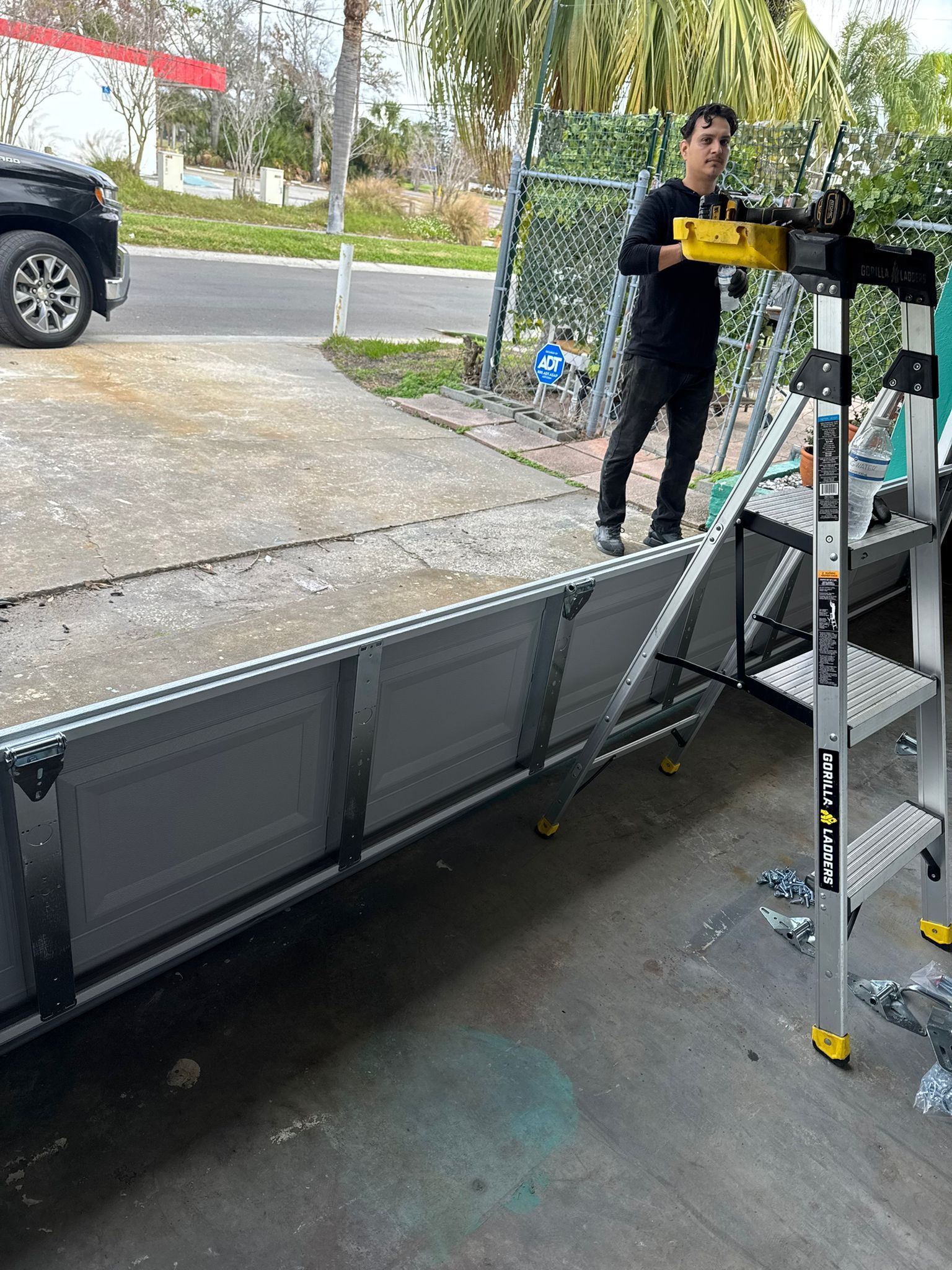 A man is standing on a ladder next to a truck.