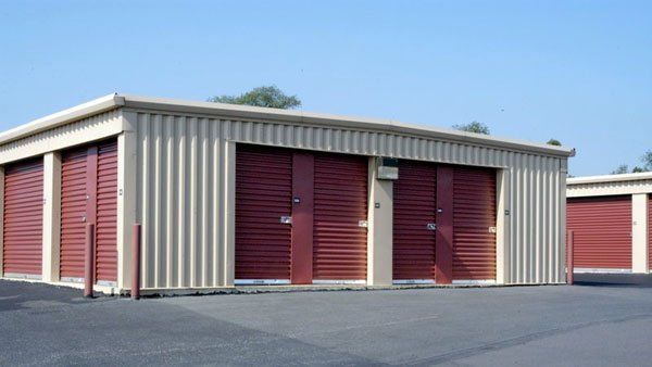 A row of storage units with red doors on a sunny day.