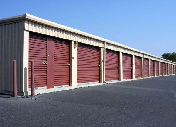 A row of storage units with red doors on a sunny day