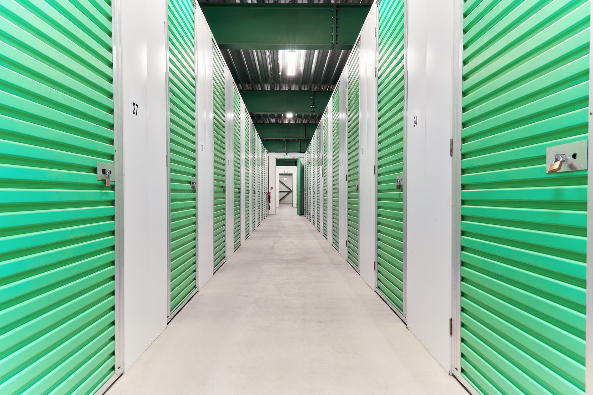 A long hallway filled with green and white storage units.