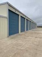 Storage units in a row, with blue doors and tan walls.