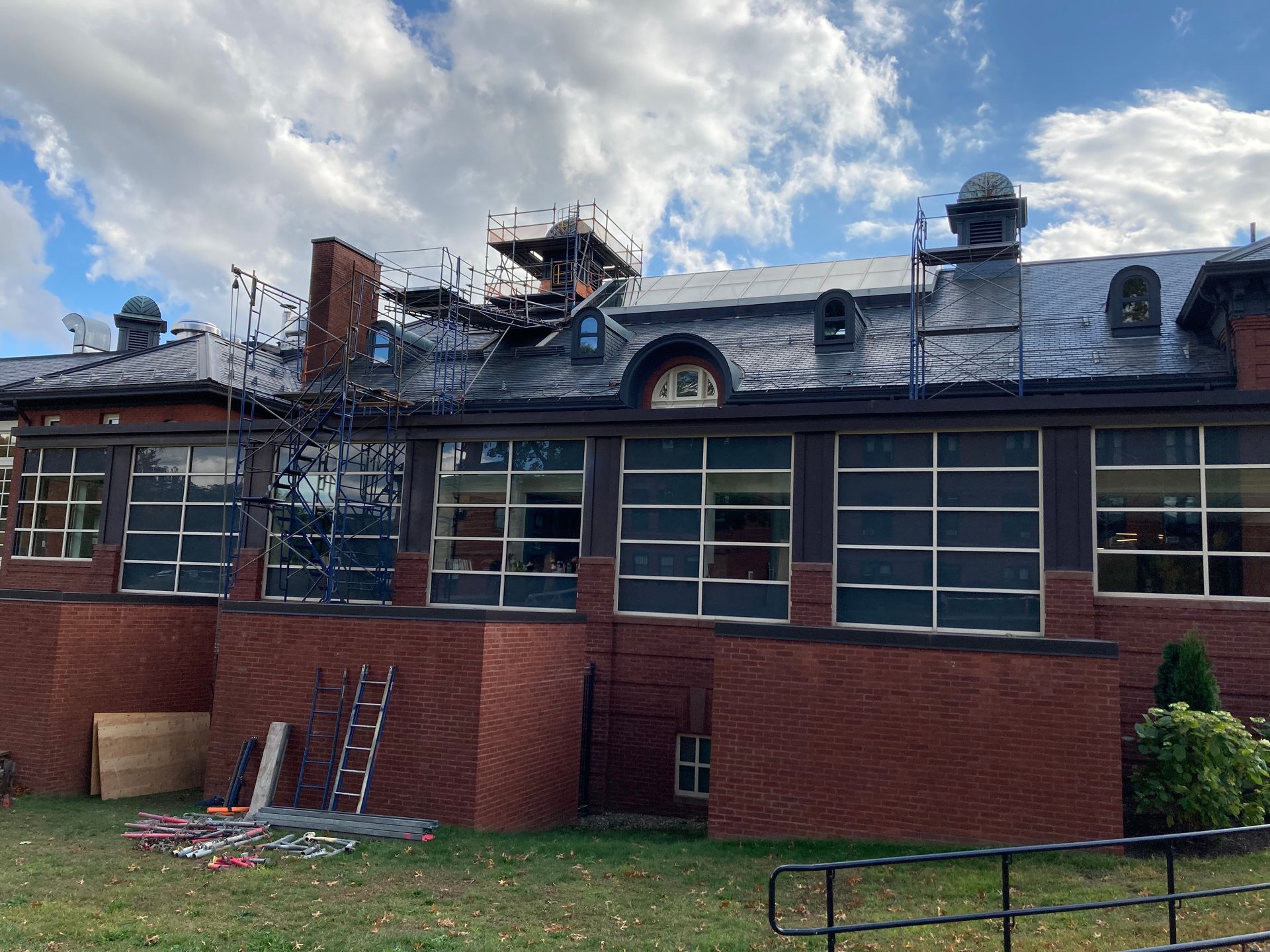 A large brick building with a roof that is being remodeled.