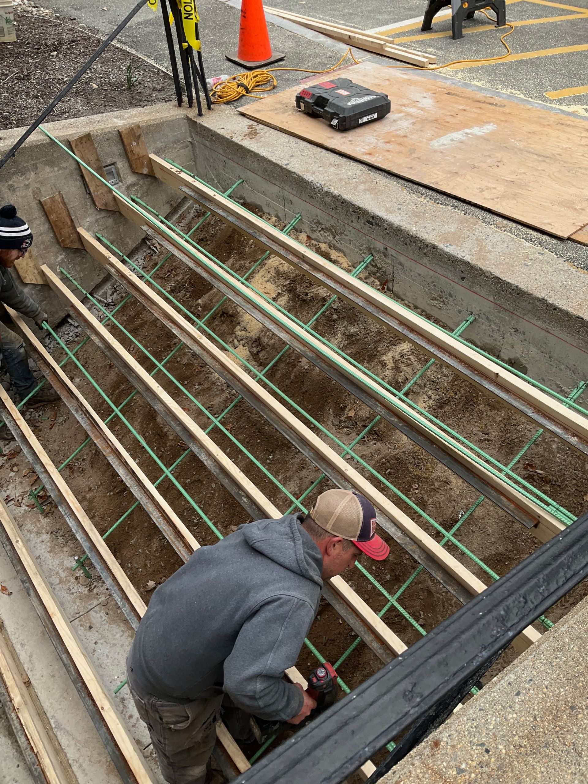 A group of construction workers are working on a concrete staircase.