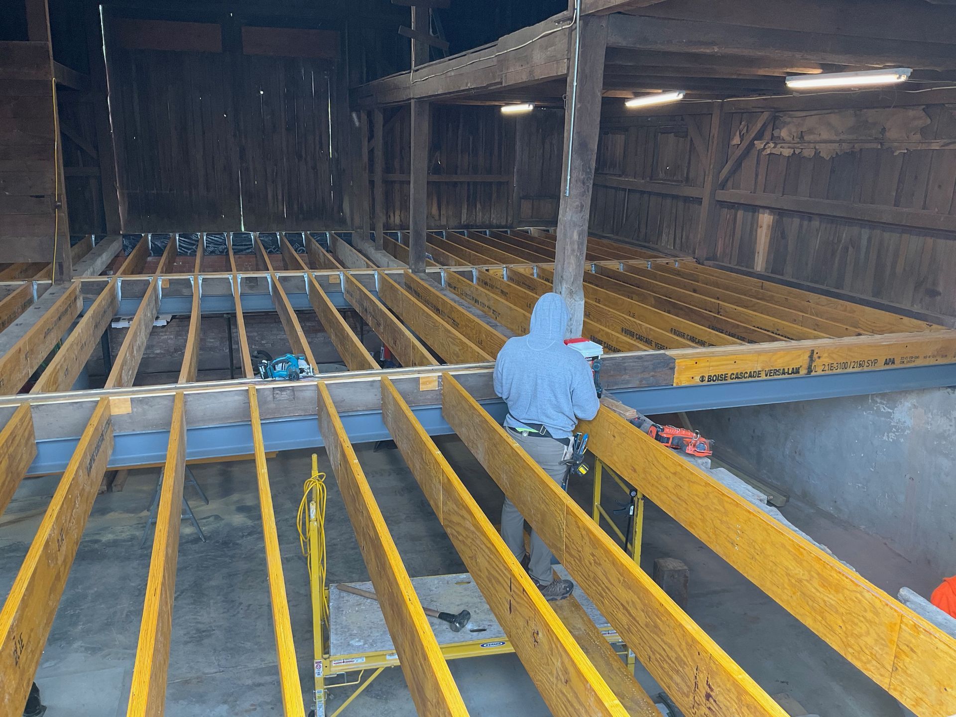 A man is working on a wooden floor in a building.