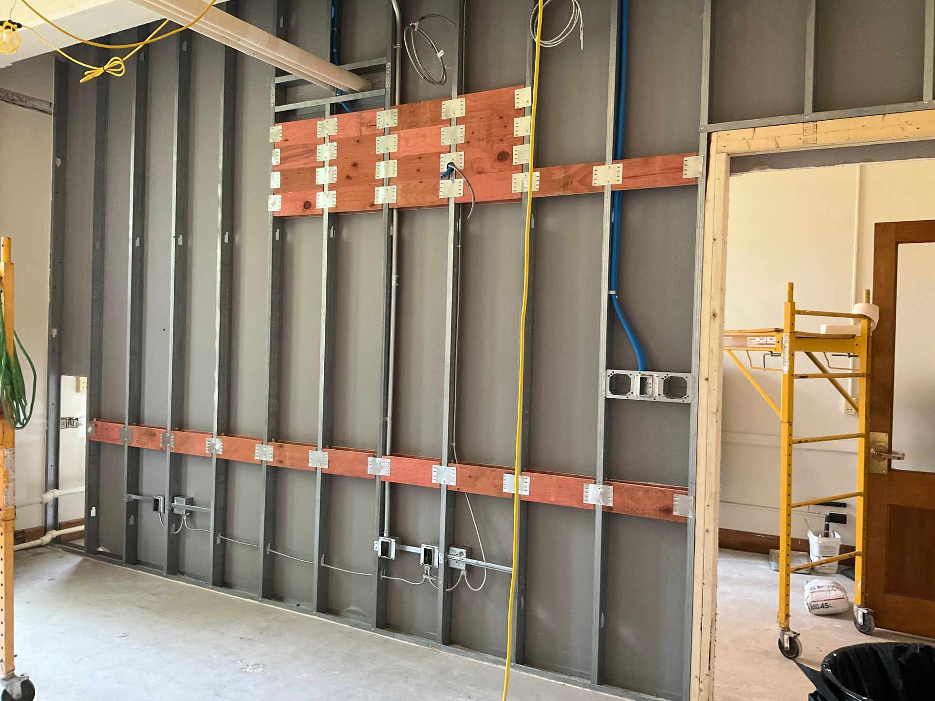 A room with a scaffolding and electrical wires on the wall