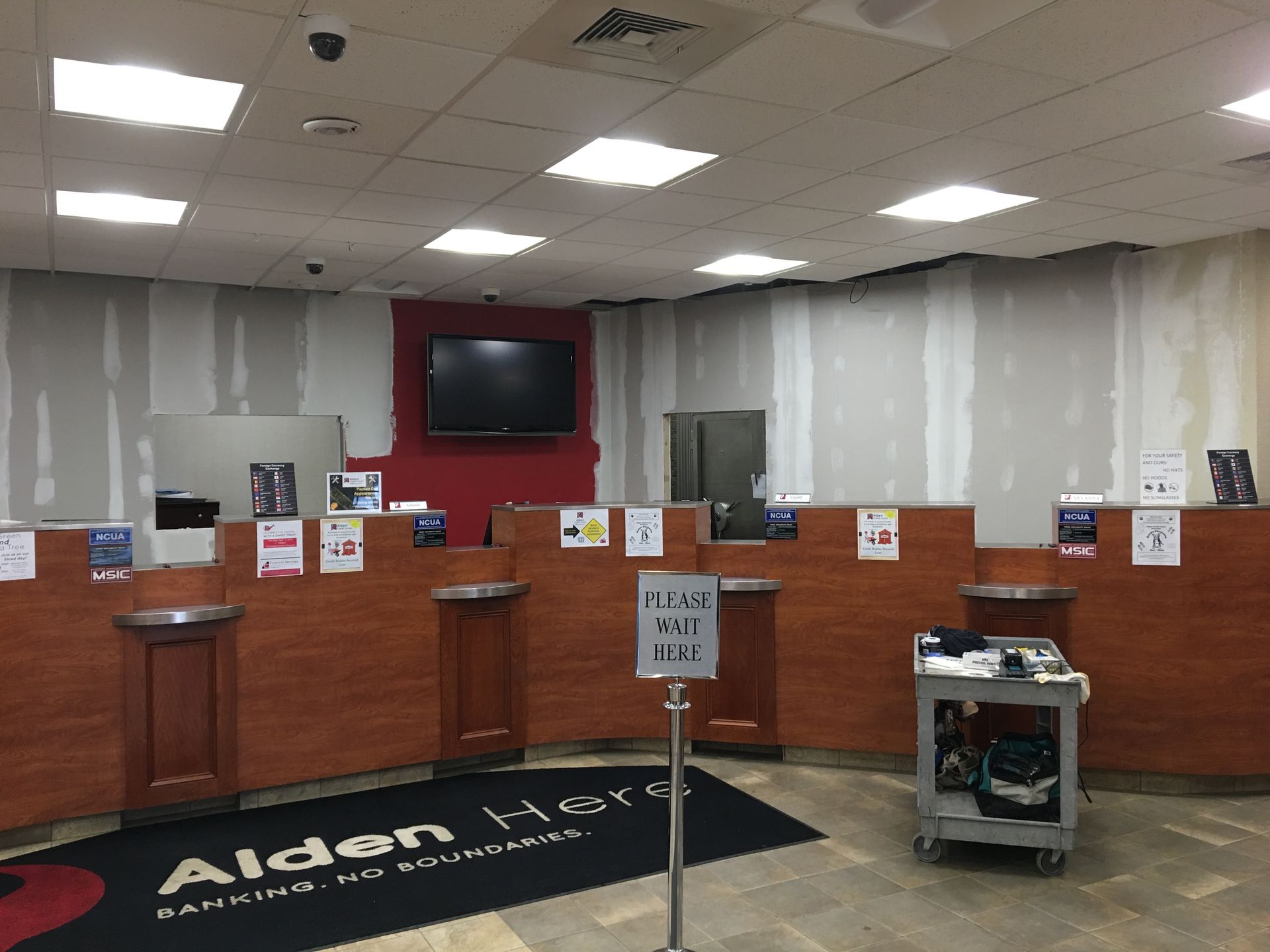 An empty bank with a sign that says please wait here