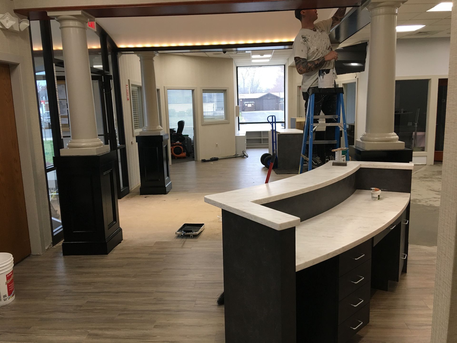 A man is painting the ceiling of a building.