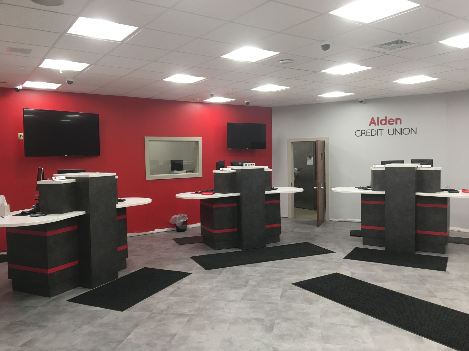 A large room with red walls and a sign that says aiden credit union