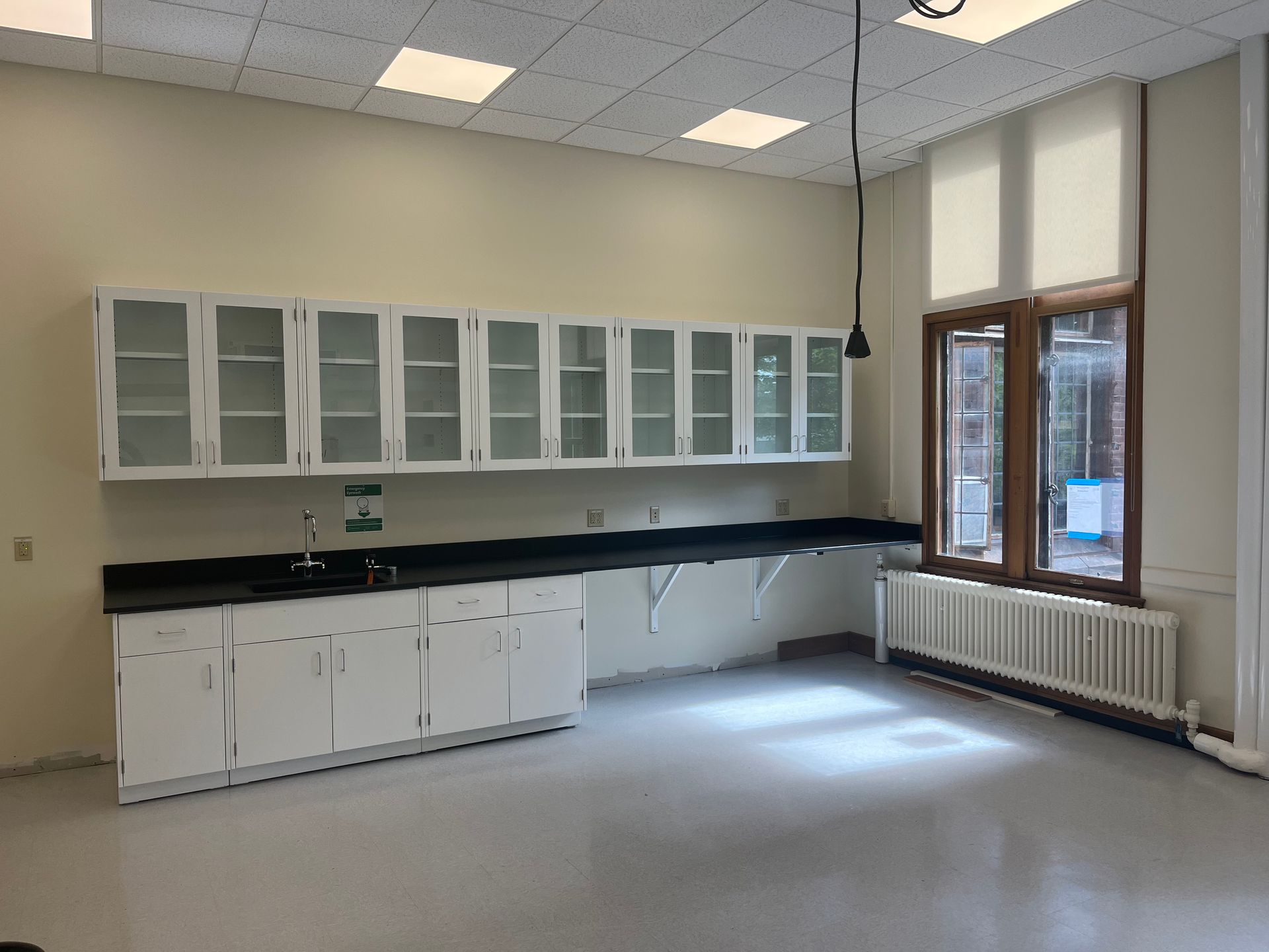 An empty kitchen with white cabinets and black counter tops