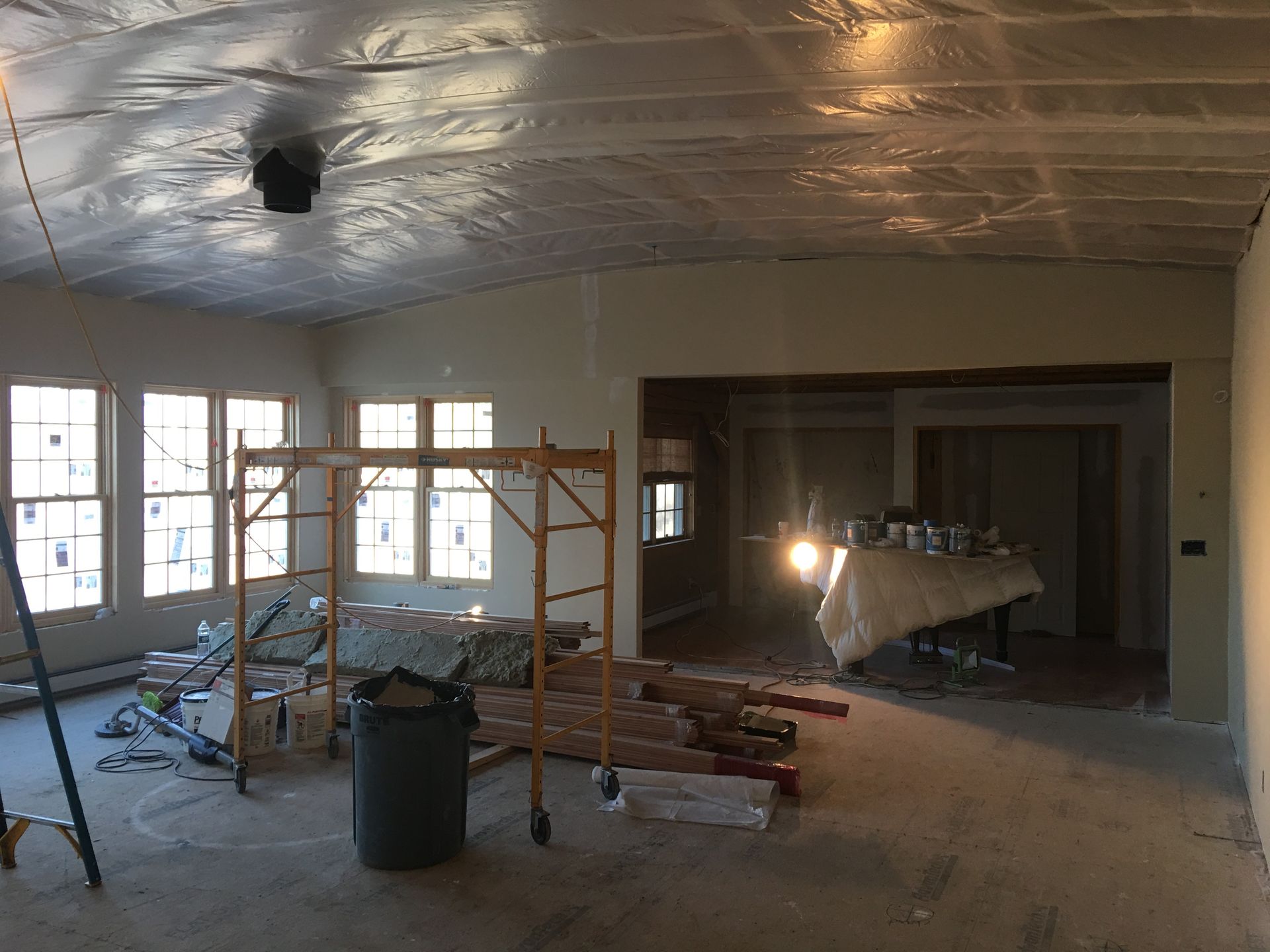 A large room with a lot of windows and scaffolding in it