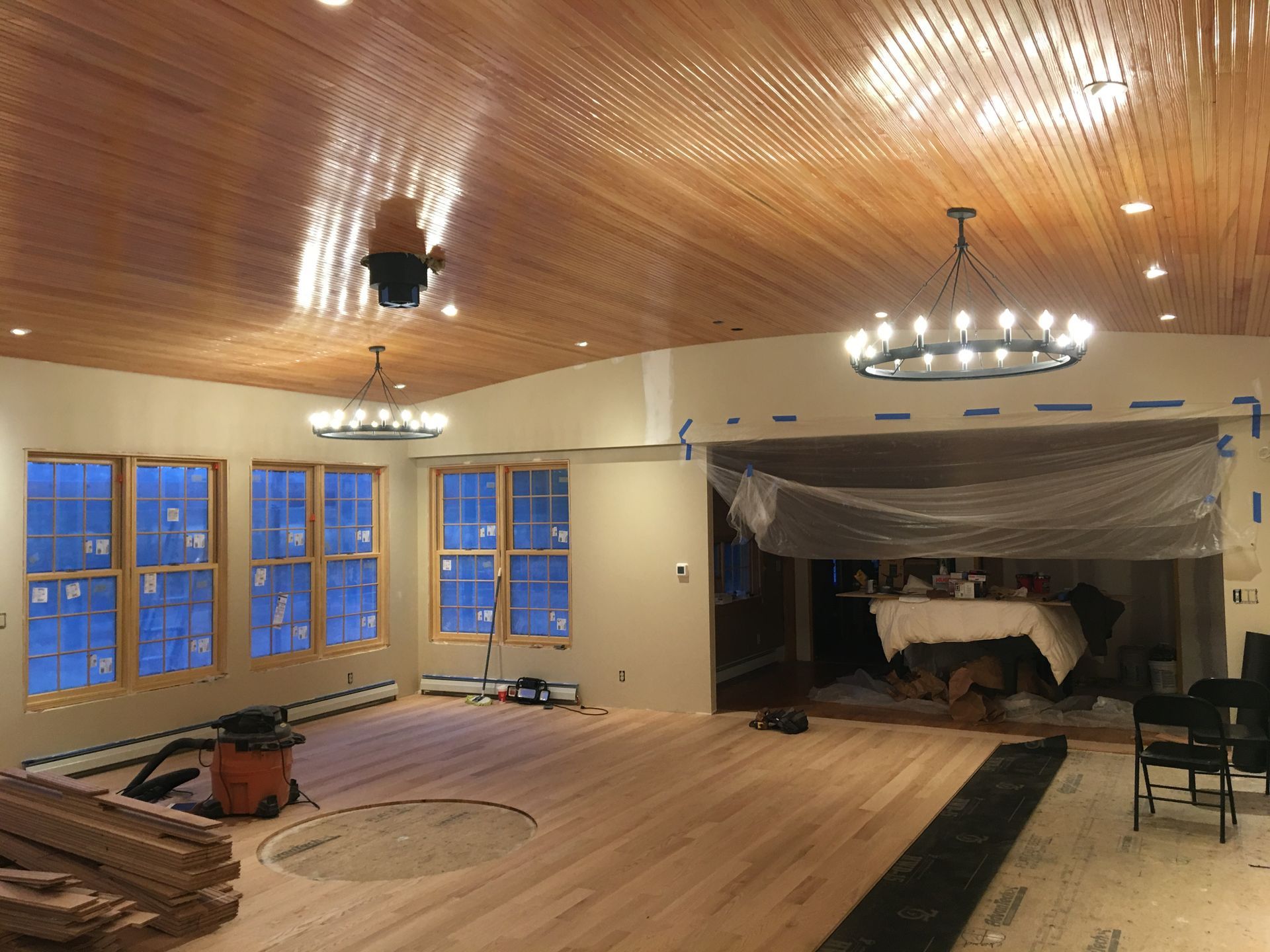 A large room with a wooden ceiling and lots of windows