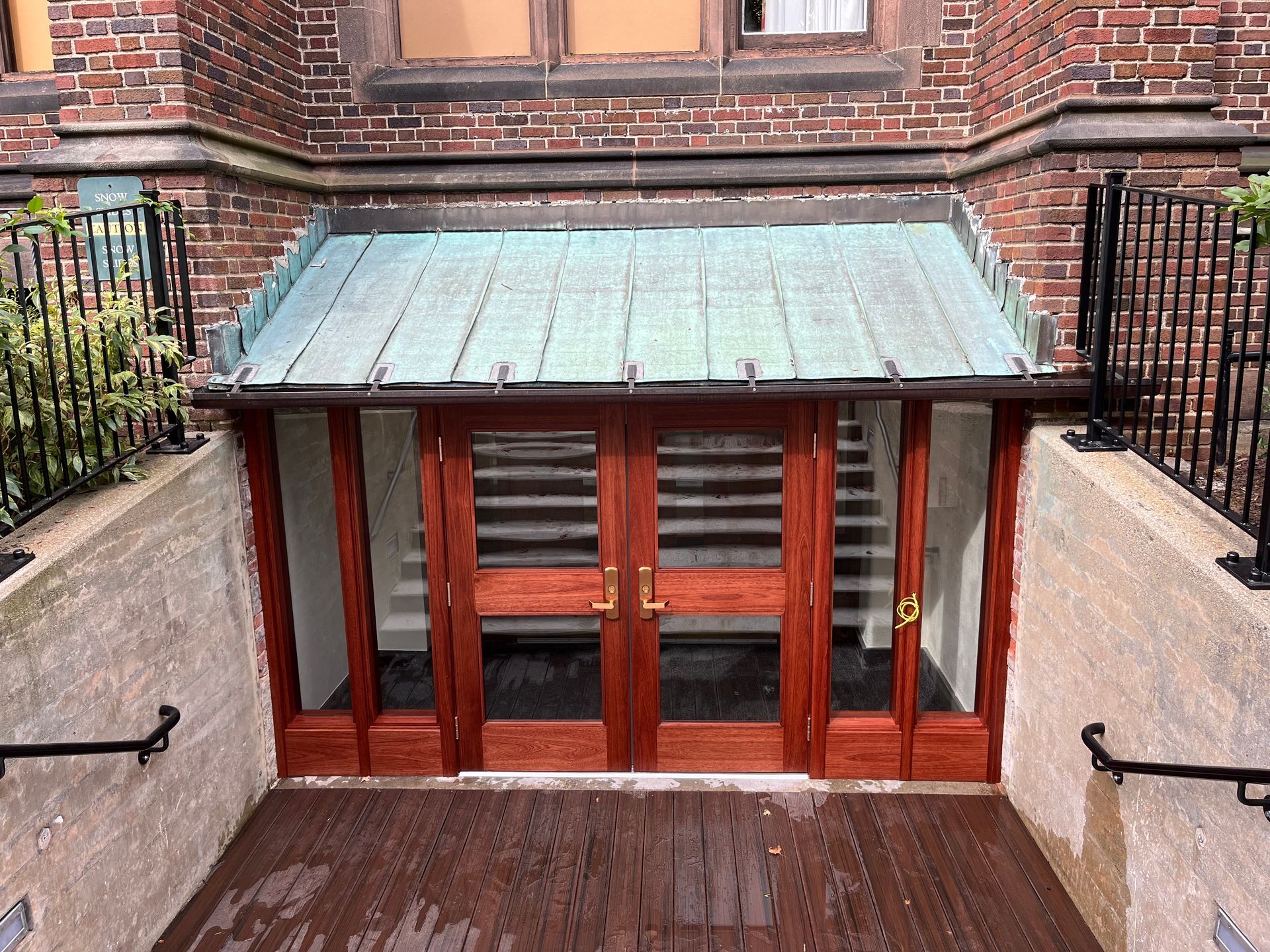 A brick building with a wooden door and stairs leading to it.