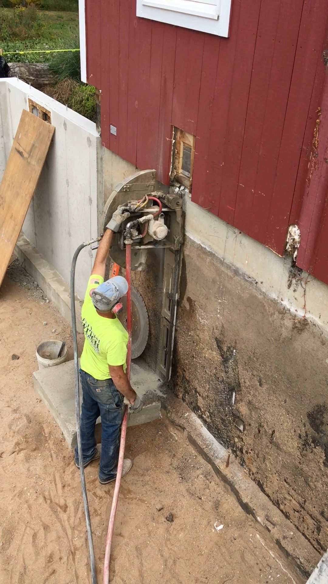 A man is cutting a hole in a wall with a machine.